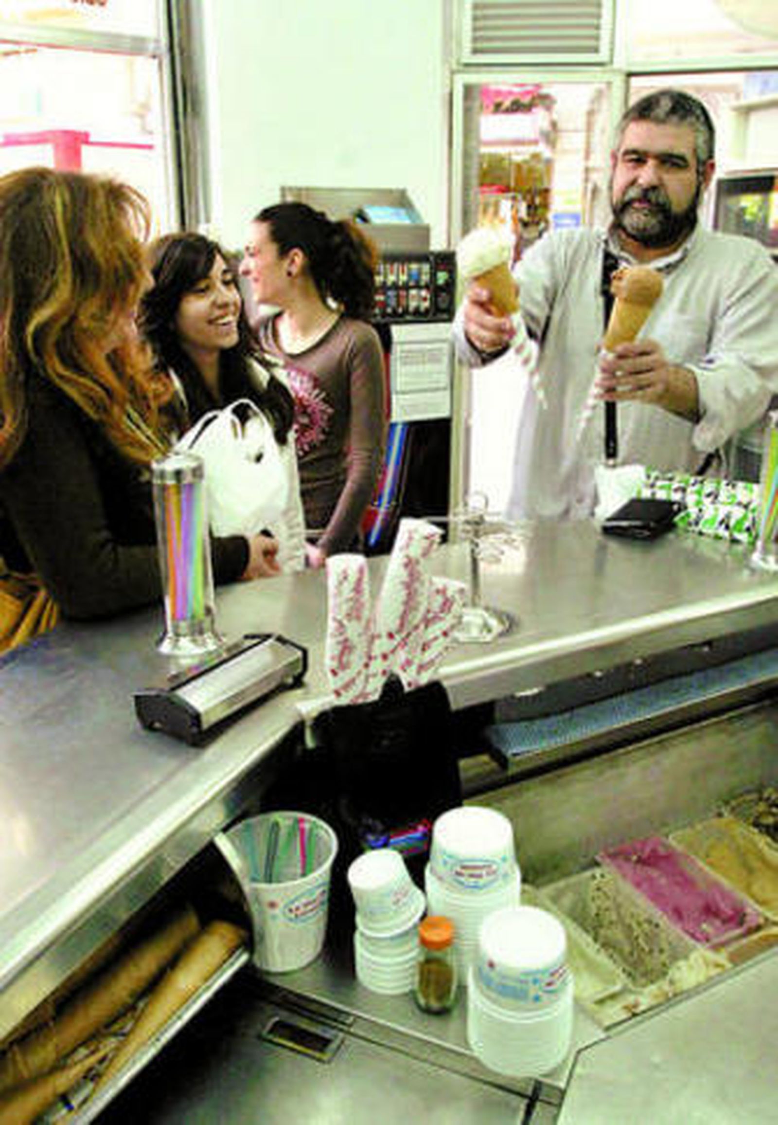 Un hombre sujeta dos barquillos de helado.