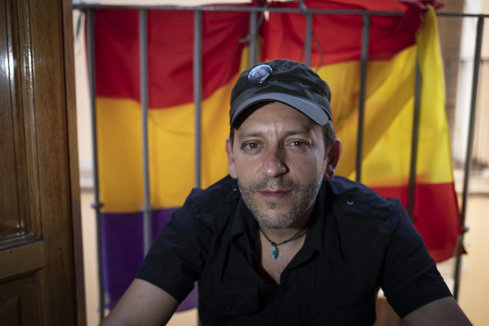 Javier Cuesta, agredido el sábado por cuatro hombres, posa en su casa con la bandera republicana y la española.
