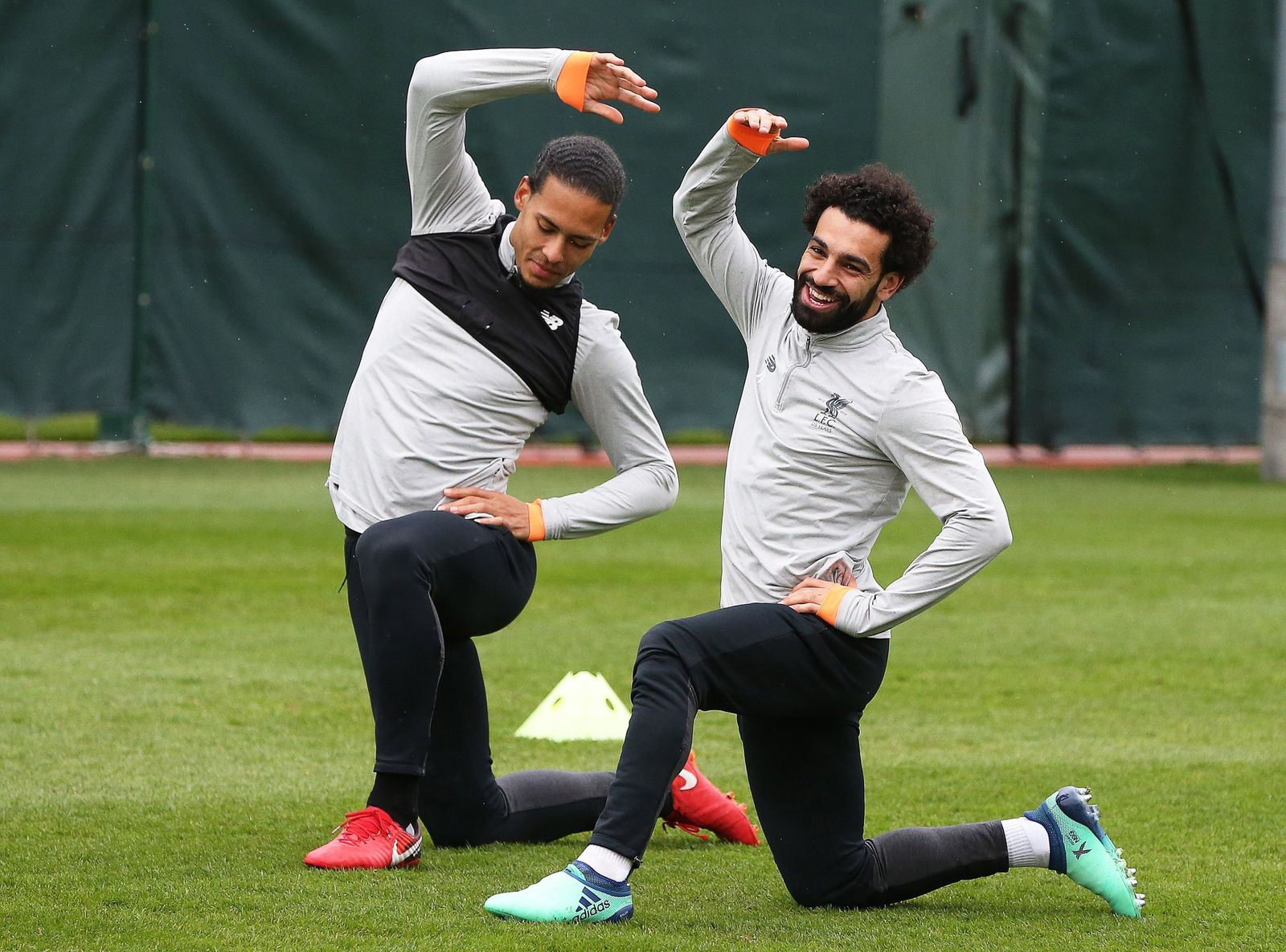 El central Virgil van Dijk estira junto a Mohamed Salah.