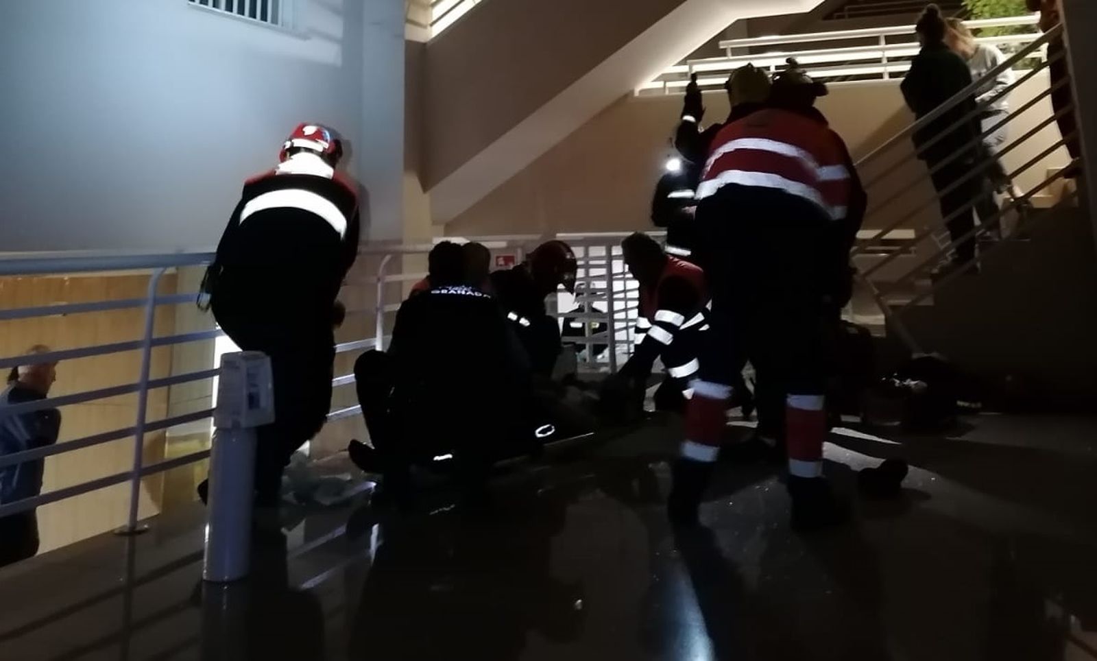 Los efectivos atendiendo al joven herido tras precipitarse desde un edificio.