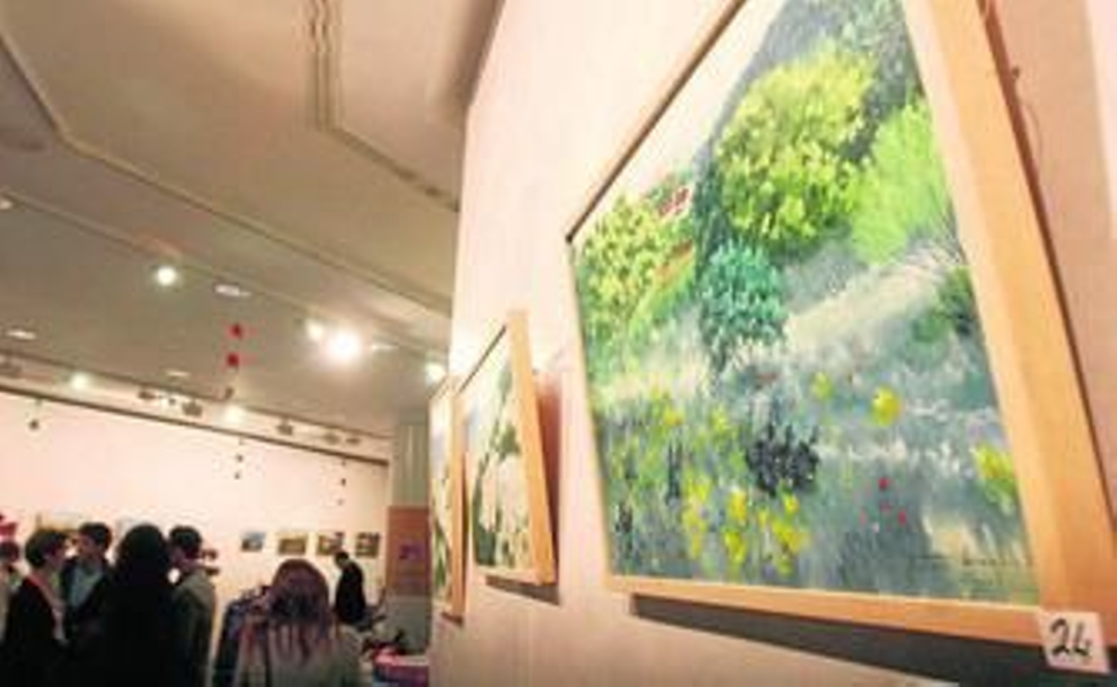 Distintos cuadros de la muestra pictórica y uno de los stand del mercadillo solidario de Caminar.