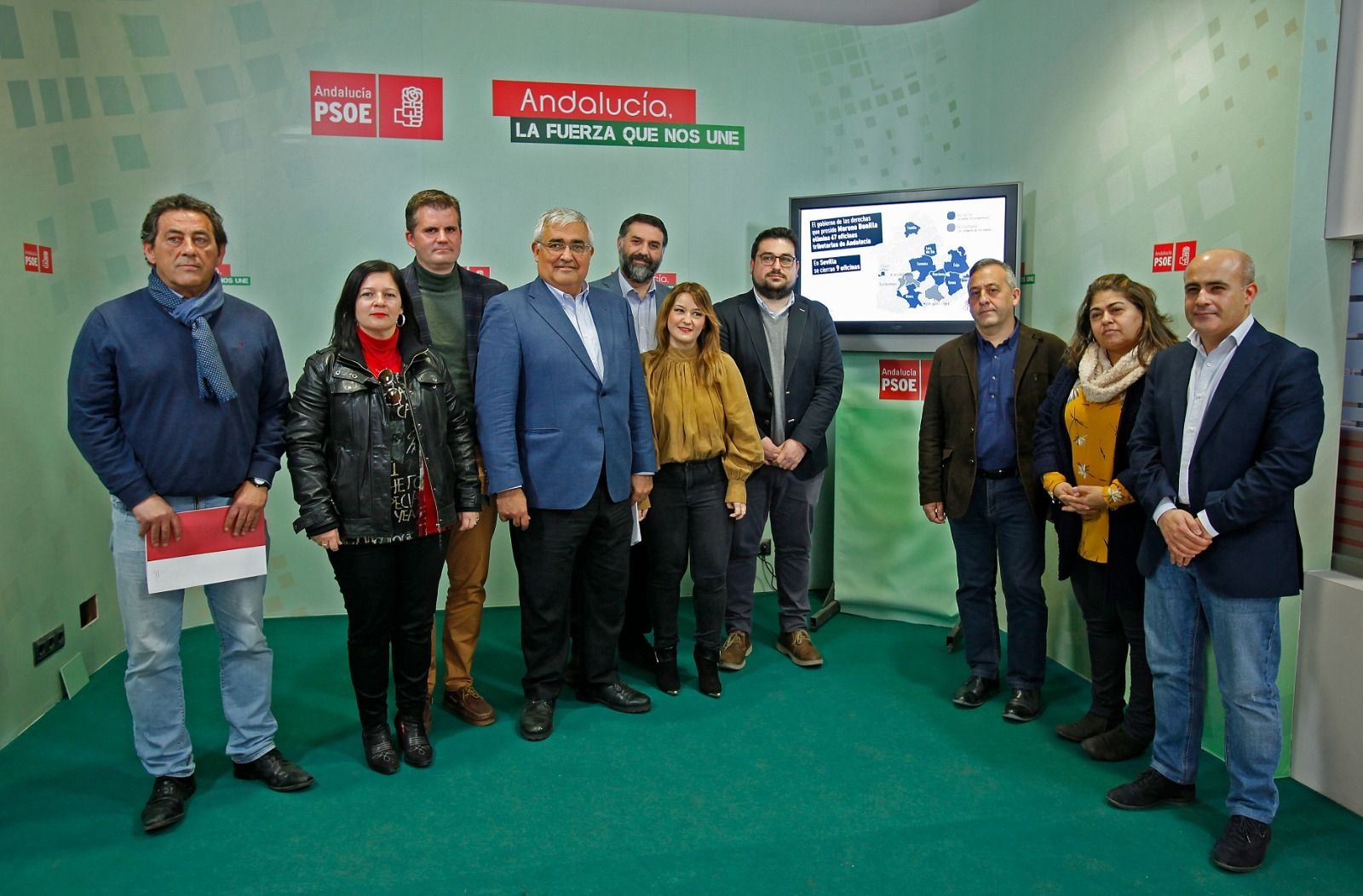 Alcaldes, concejales y parlamentarios socialistas junto a la secretaria provincial y el mapa de las oficinas.
