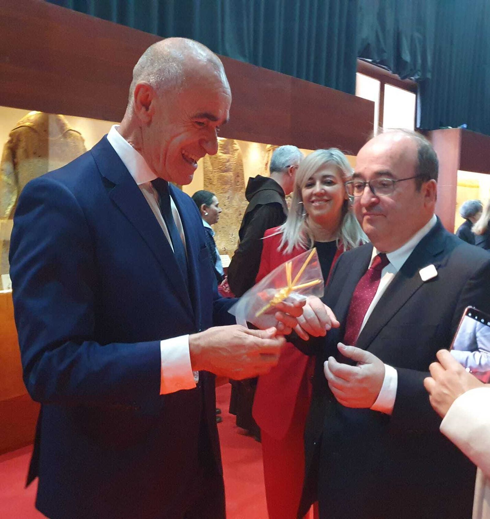 Antonio Muñoz entrega al ministro Miguel Iceta una palma rizada de solapa.