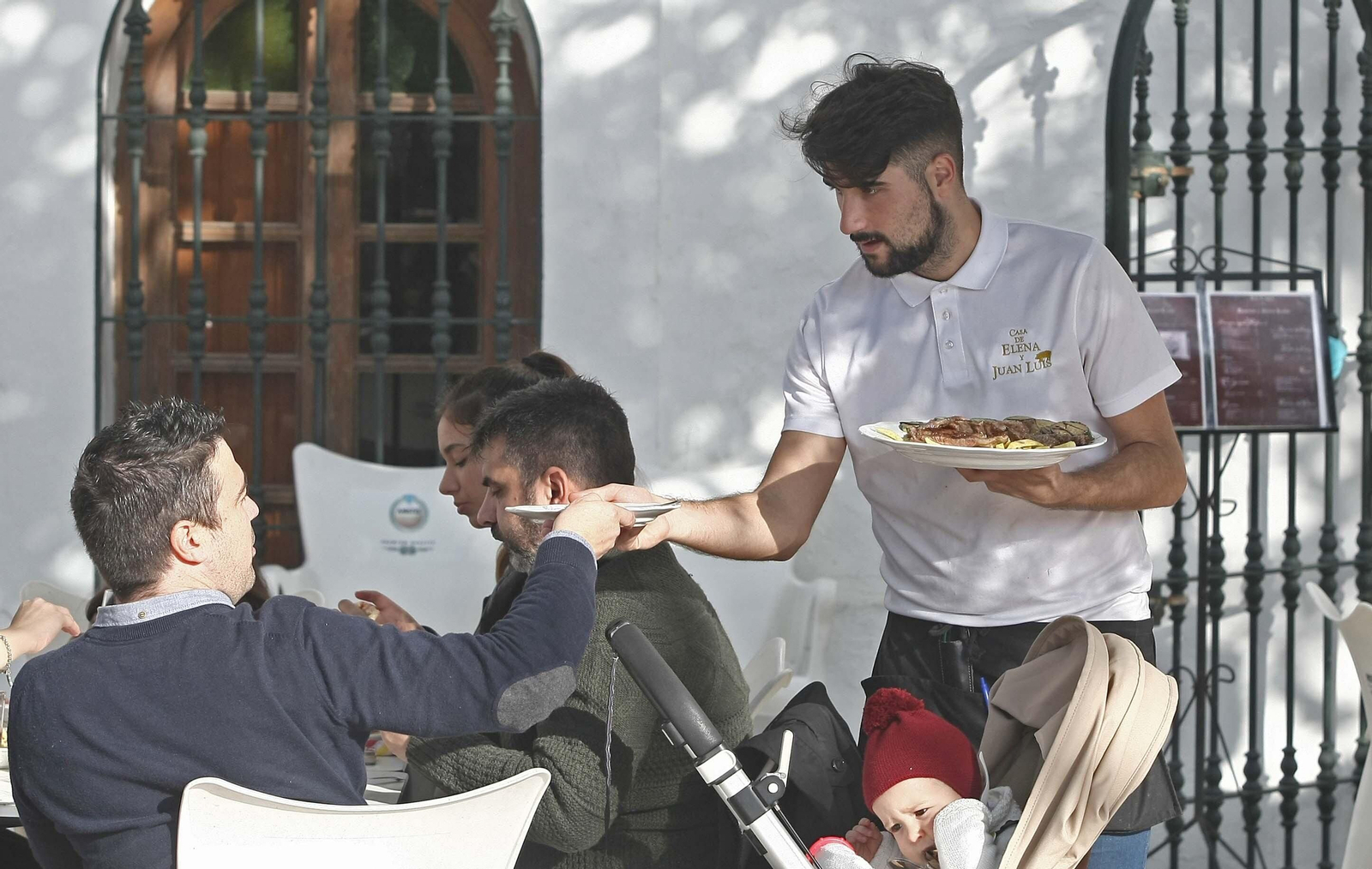 Un camarero atiende a los clientes de una terraza en Tarifa.