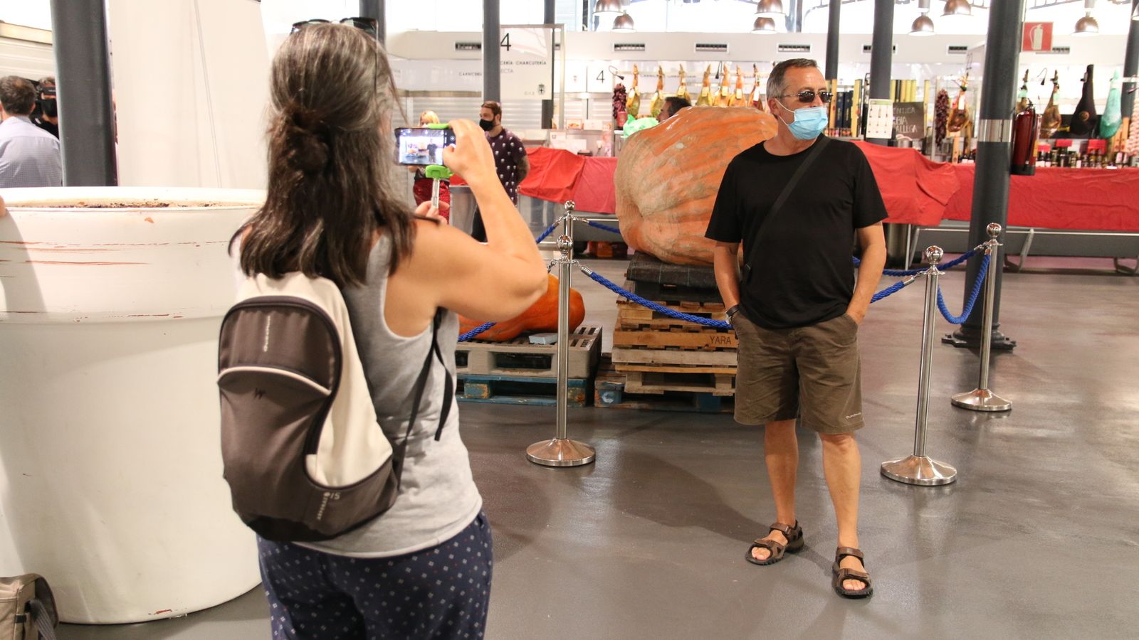 Visitantes del mercado se fotografían con la calabaza.