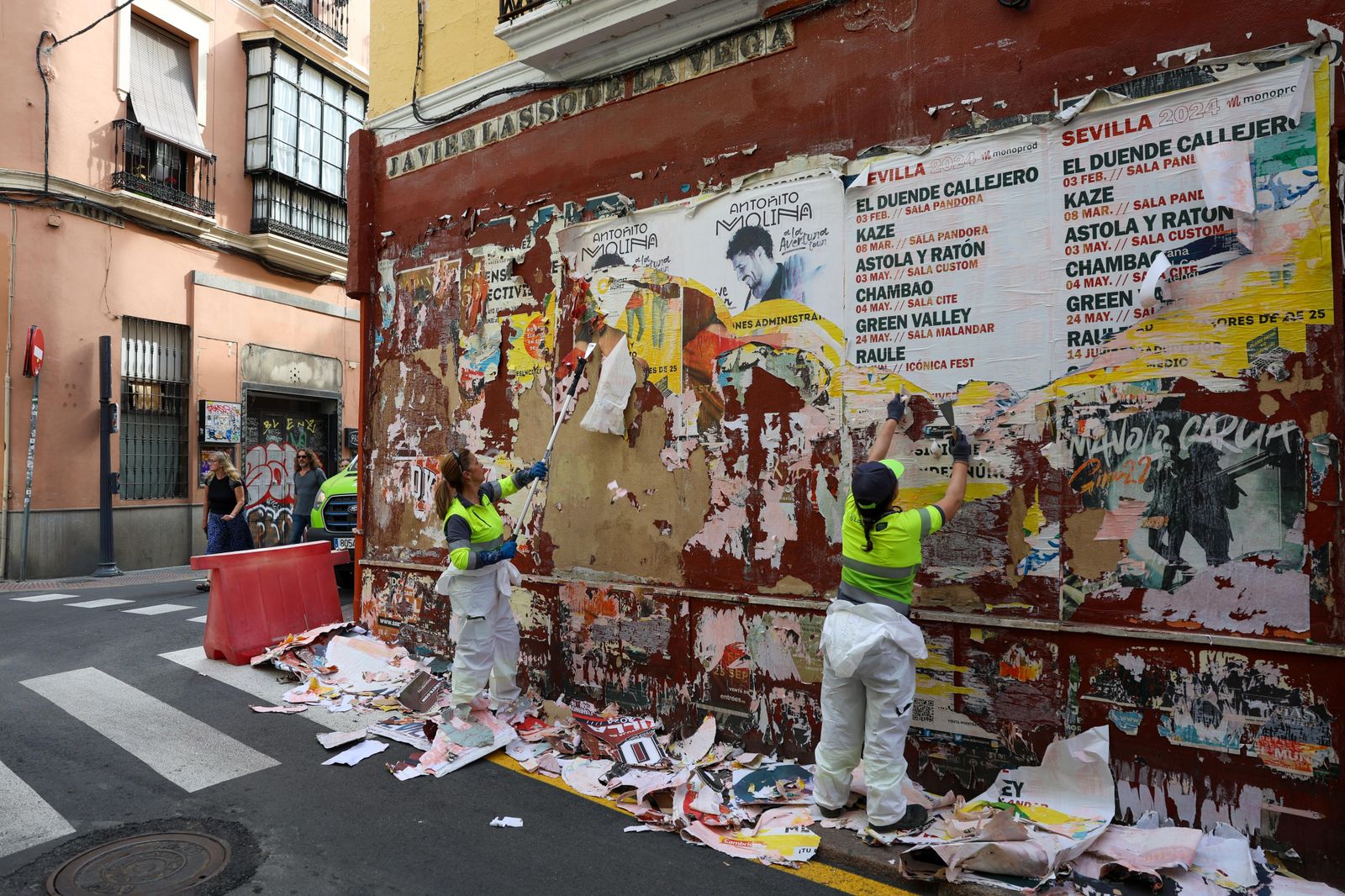 Dos operarias retirando cartelería indebida en la calle Javier Lasso de la Vega.