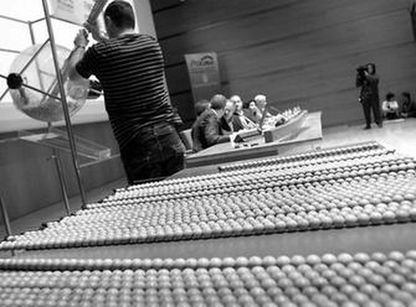 Un empleado de Procasa llena el bombo con las bolas en las que figuraban los números de las solicitudes.