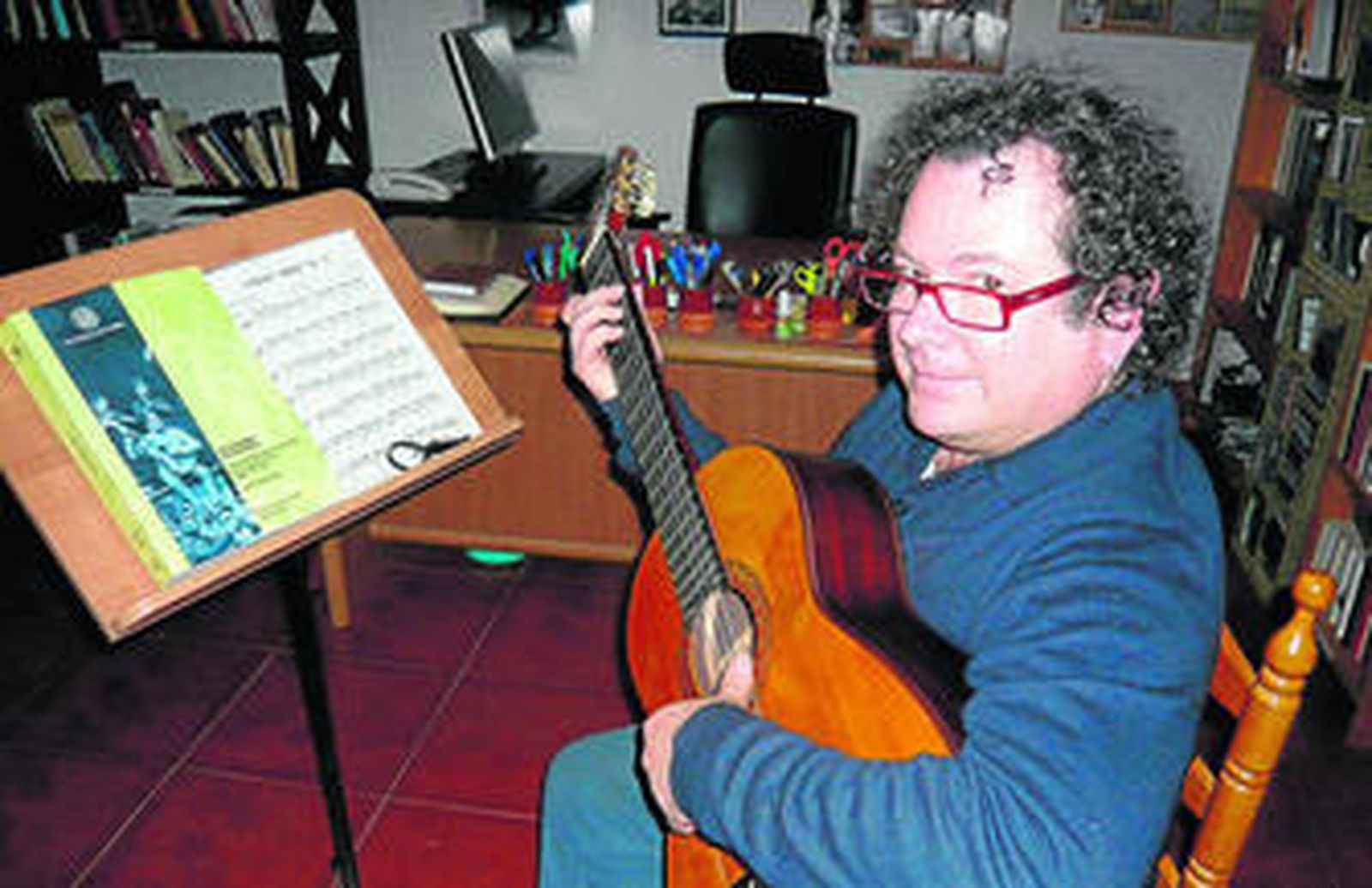 Norberto Torres con su guitarra y su recién publicado tesis doctoral.