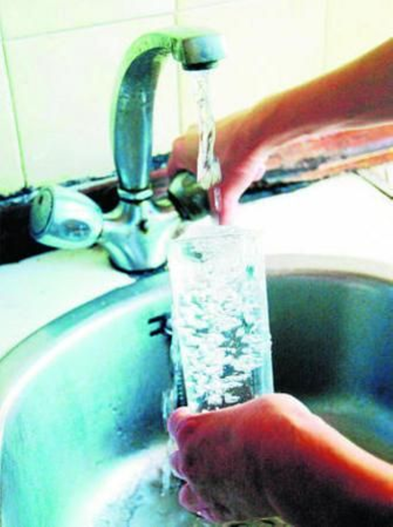 Un hombre llena un vaso de agua.