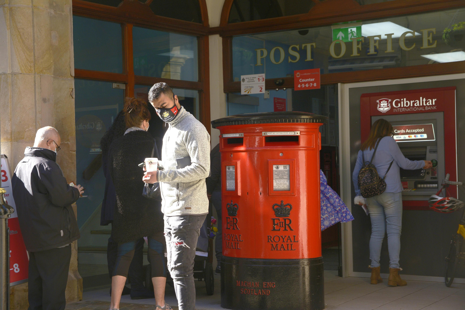 Una cola de personas las puertas de la oficina de correos de Gibraltar.