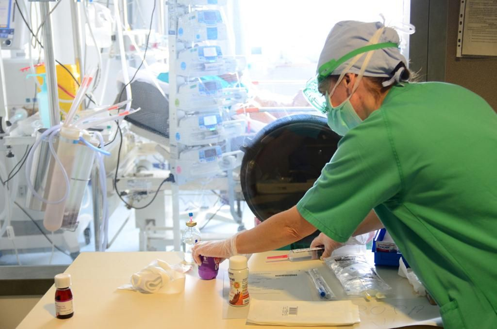 Una profesional prepara un tratamiento a un paciente de la UCI.