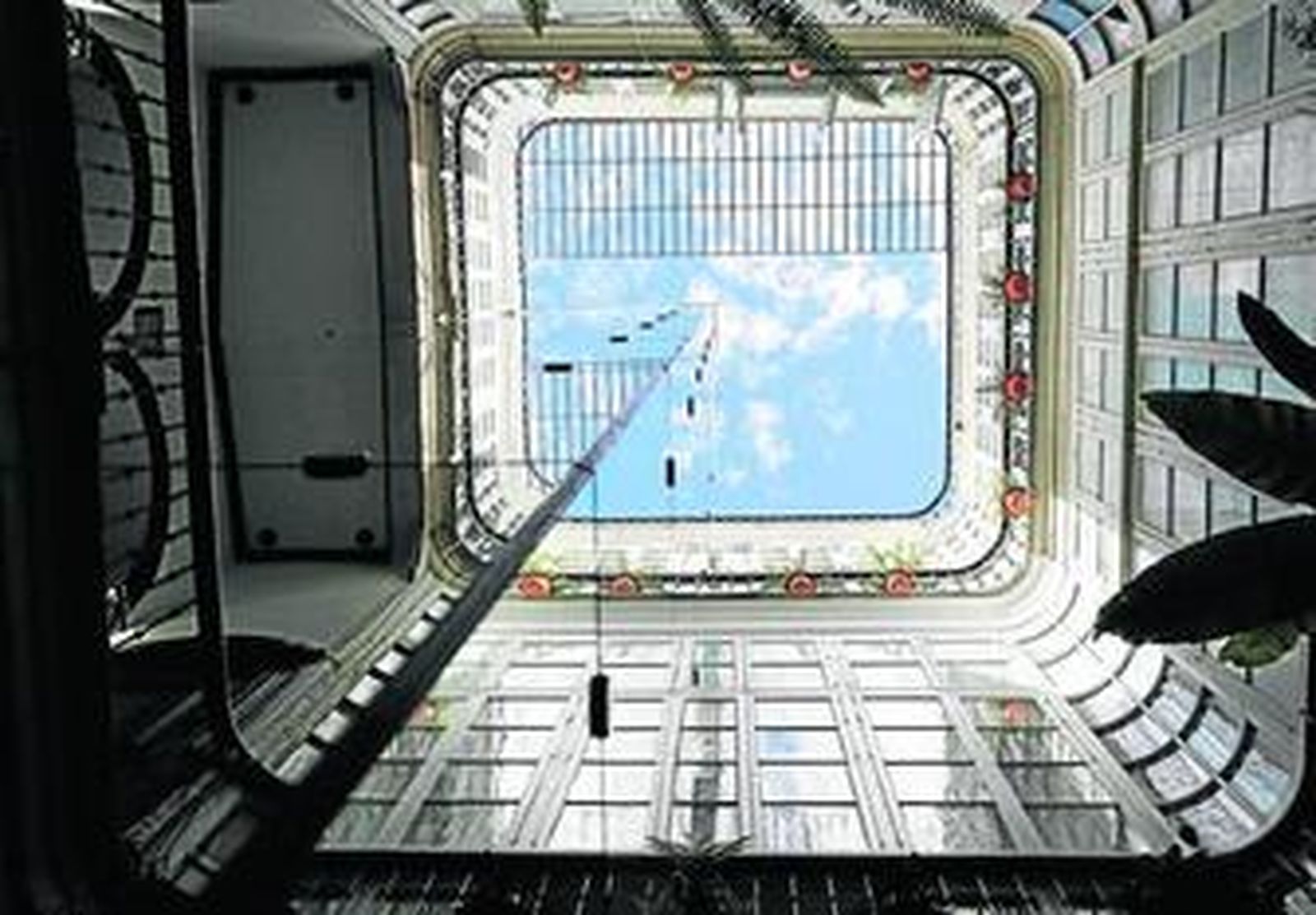 Ascensor con torre de espejo instalado en el patio de una finca de la calle Columela.