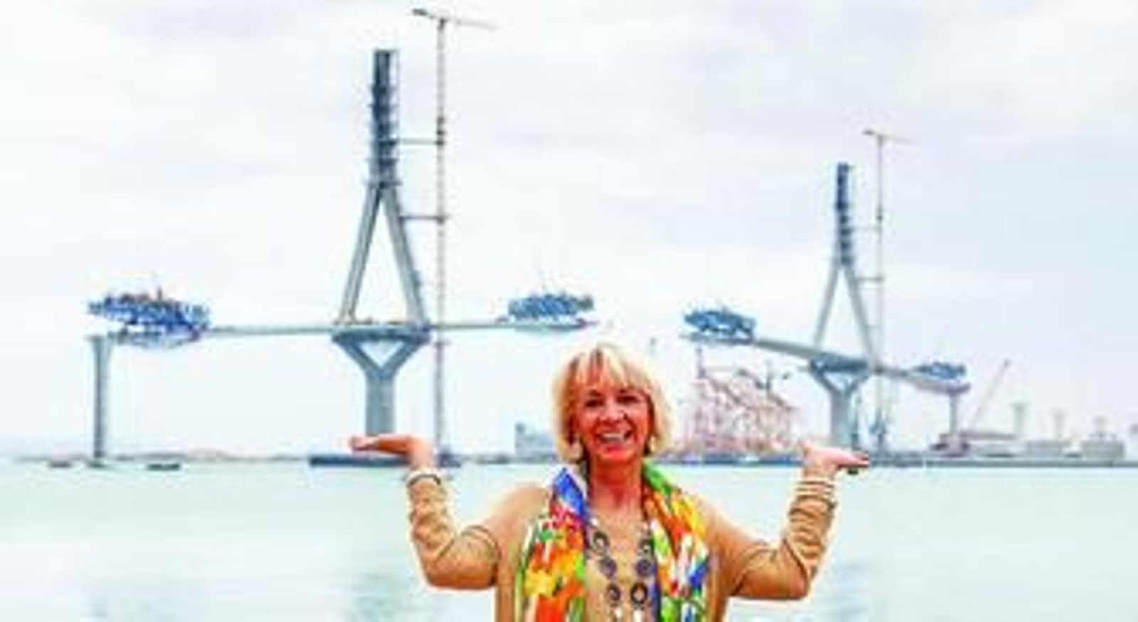 Teófila Martínez posa en la barriada de la Paz con el puente al fondo, en el que se ve cómo ya casi ha alcanzado las pilas 11 y 14.