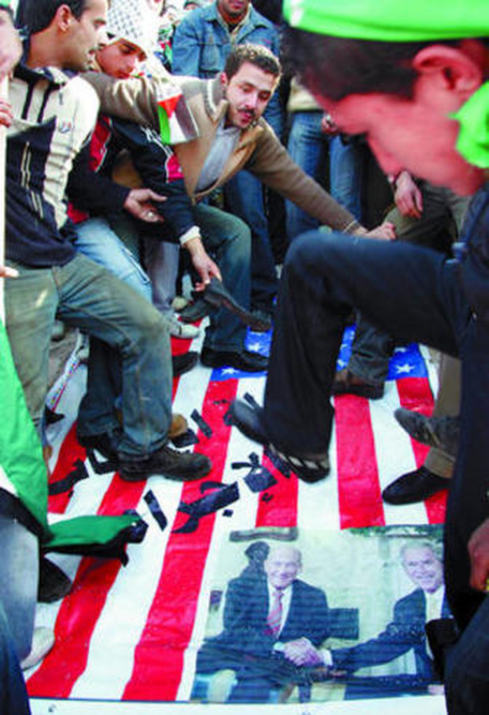 Unos jordanos pisotean la bandera de EEUU decorada con la imagen de Bush y Olmert, en Ammán.