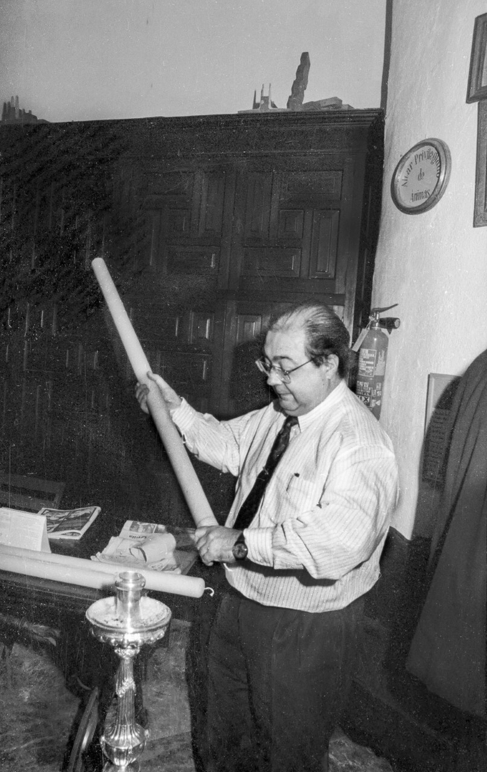 Manuel Palomino sacándole brillo al cirio de una candelería.