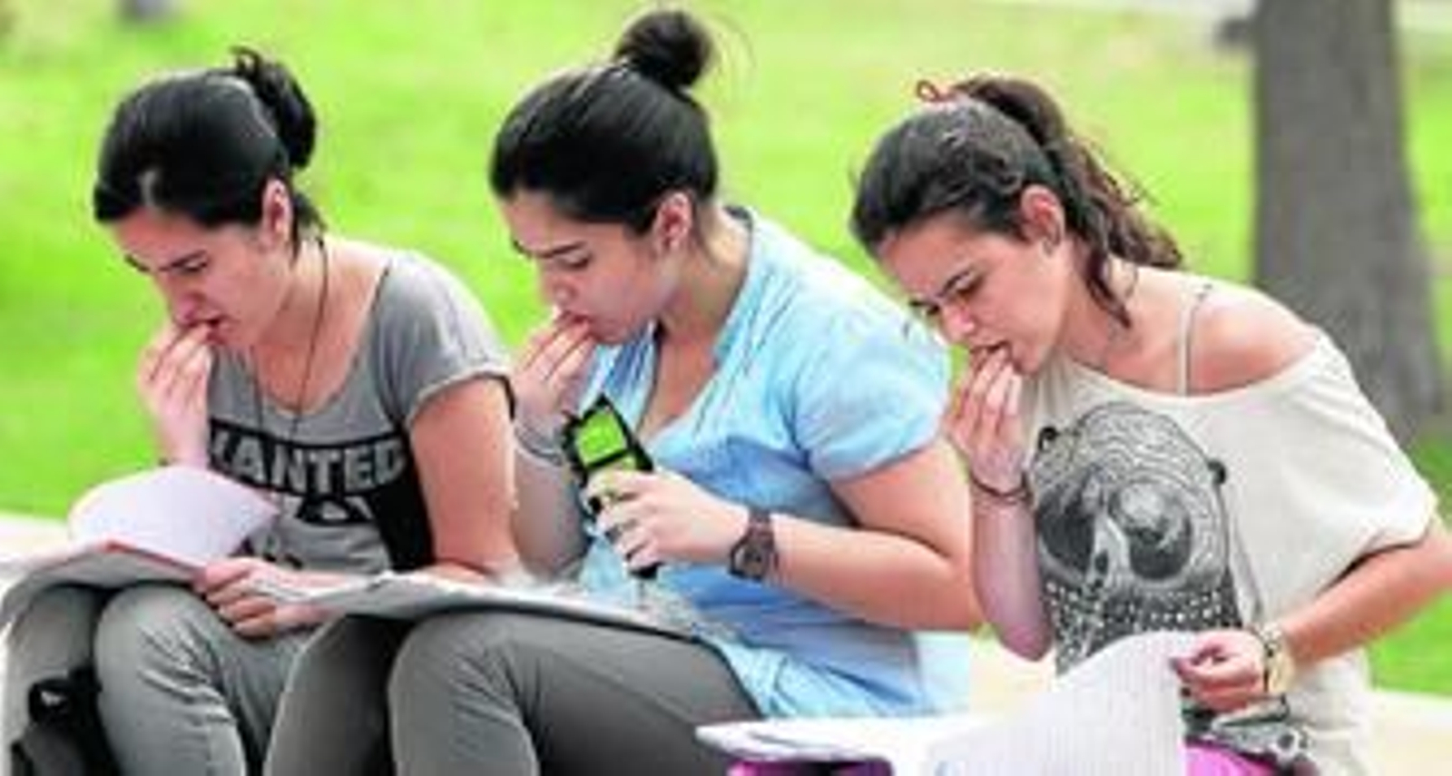 Tres alumnas repasan los apuntes y comen pipas en uno de los descansos en la UPO.