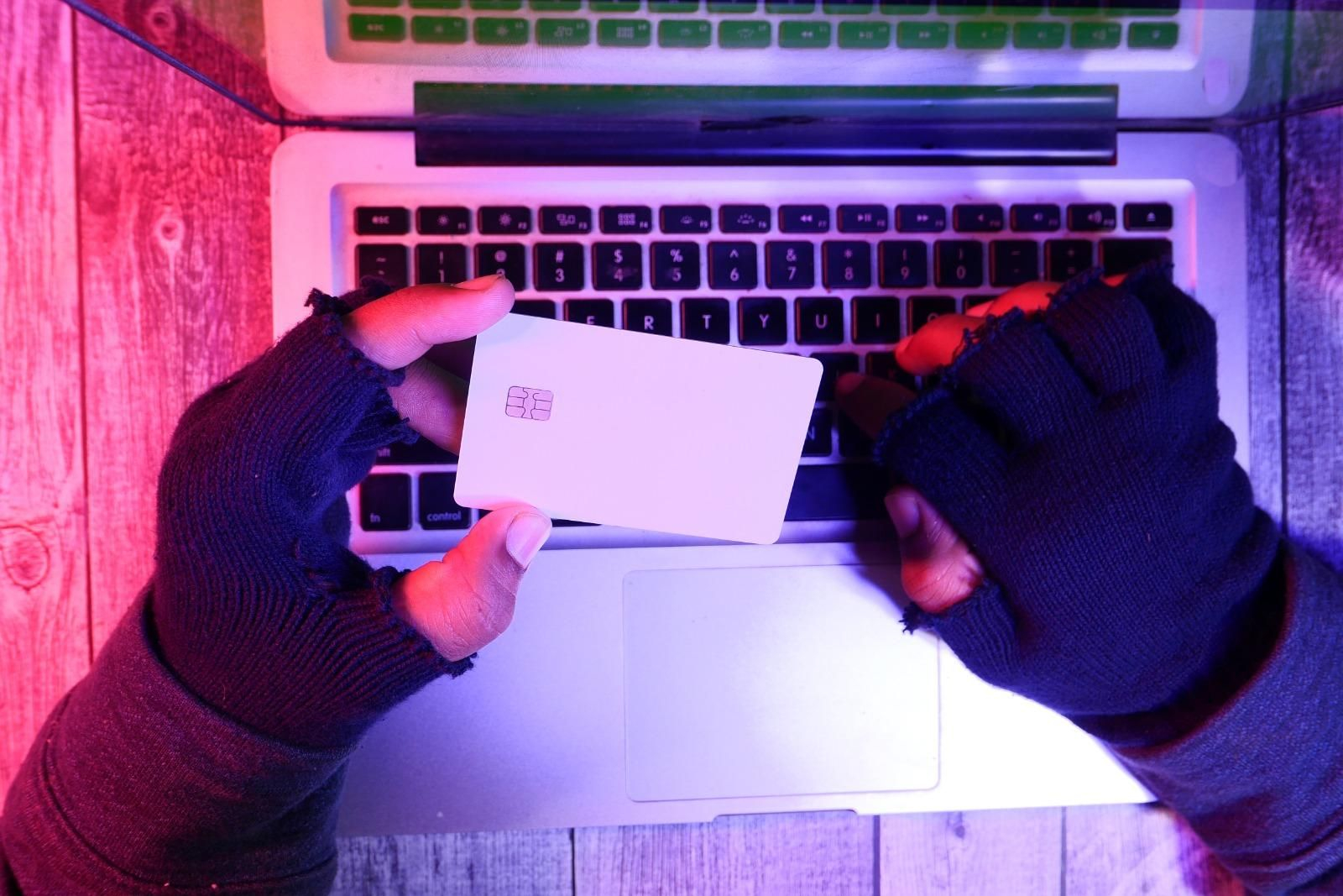 Un hacker manipula una tarjeta de crédito. Un hacker manipula una tarjeta de crédito.