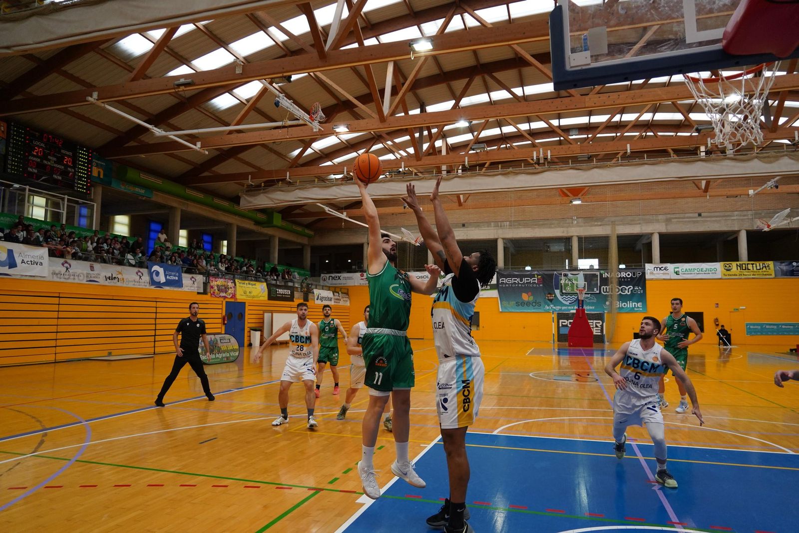 Un jugador del conjunto ejidense en plena ejecución de un tiro ante el intento de bloqueo de un rival.