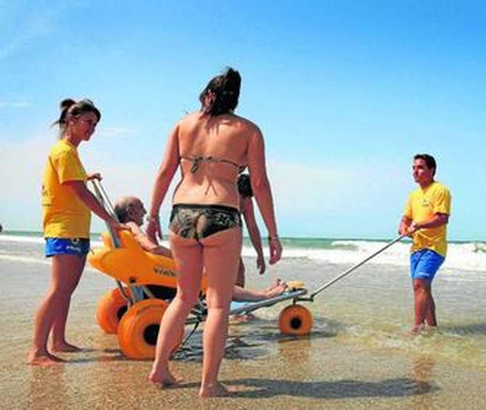 Los socorristas del Módulo Central de la Caleta ayudan a las personas de tercera edad a darse un baño a través de las sillas anfibias o 'Anfibuguis'.