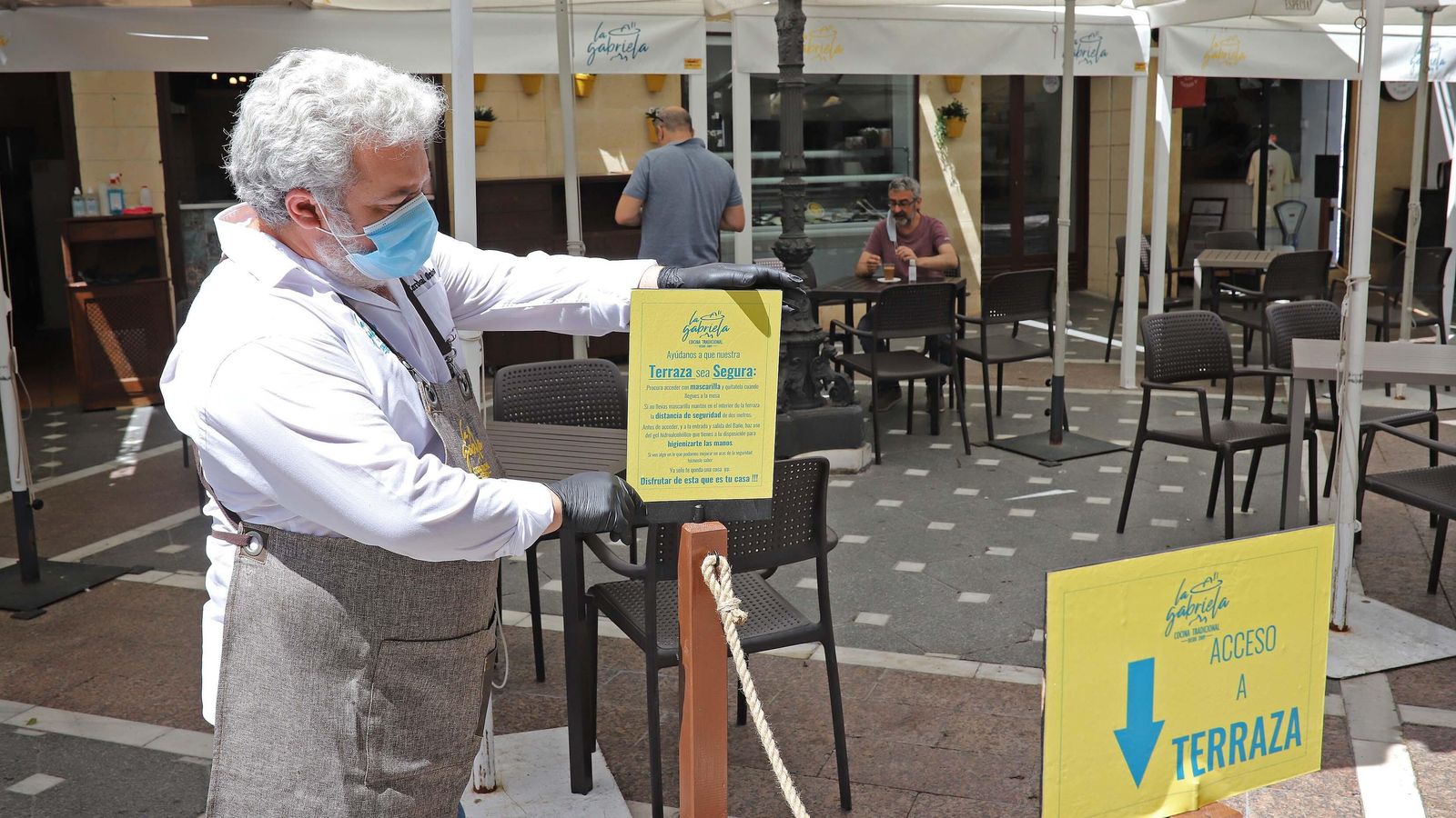 El propietario de Casa Gabriela coloca un cartel en la zona acordonada del exterior del establecimiento para controlar el acceso.
