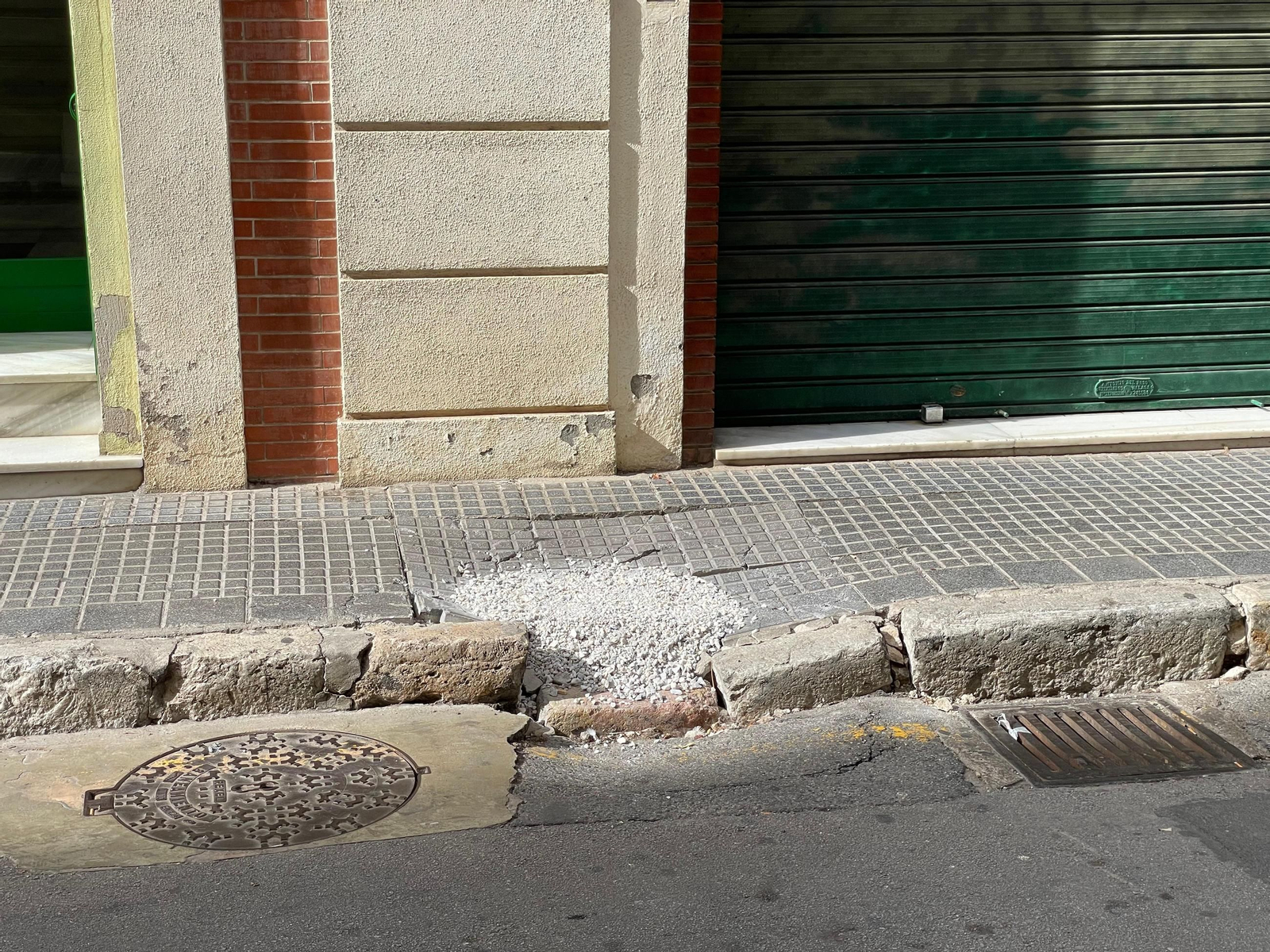 Agujero relleno de grava en calle Panaderos de Málaga.
