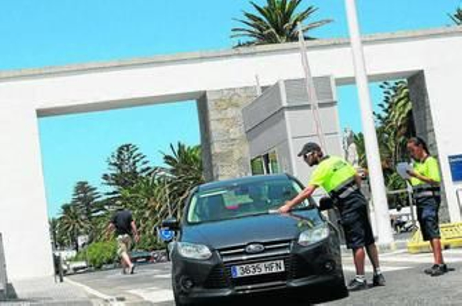 Dos auxiliares de la Operación Paso del Estrecho clasifican vehículos a su entrada en el puerto de Tarifa.