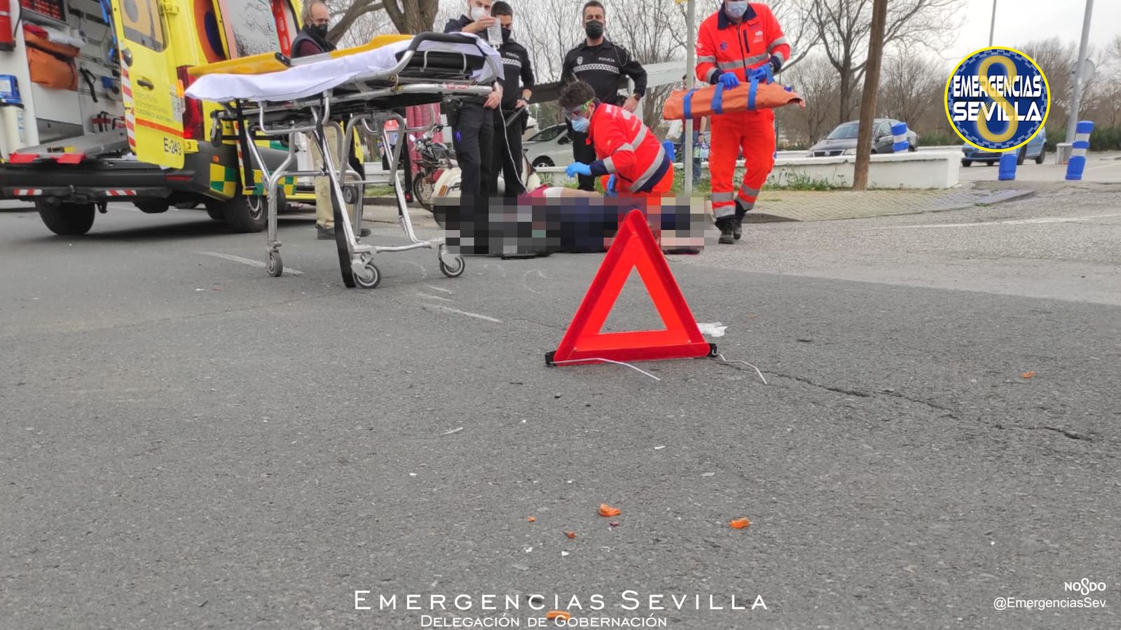 Los servicios de Emergencias atiende al motorista en el suelo.