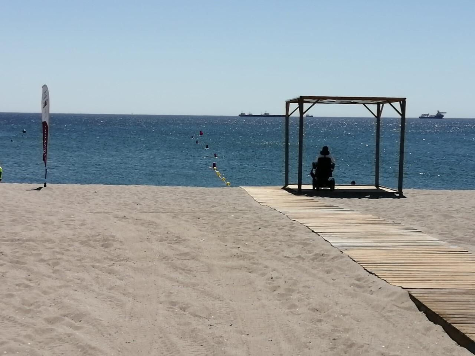 Una persona con movilidad recudida observa el horizonte desde el módulo de sombra