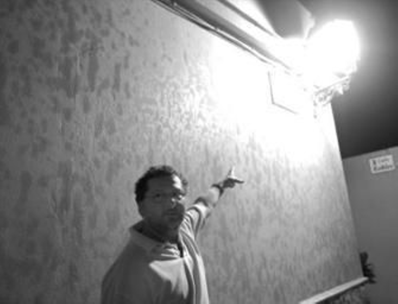 Un hombre muestra una pared manchada con el aceite hidráulico que cayó en Puente Mayorga.