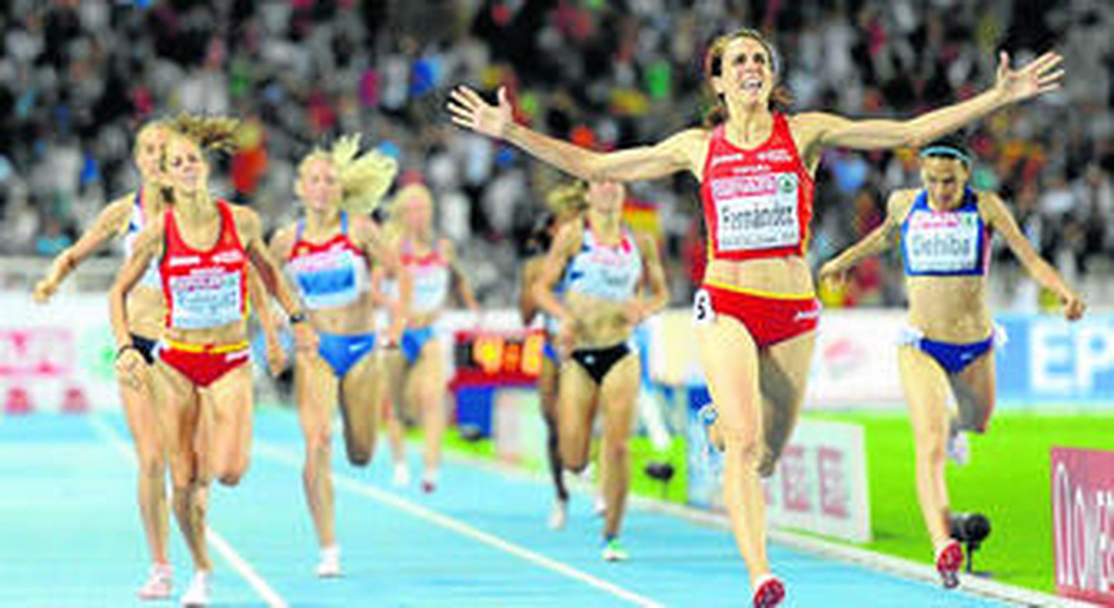 Nuria Fernández levanta los brazos en señal de victoria, con Natalia Rodríguez llegando por detrás.