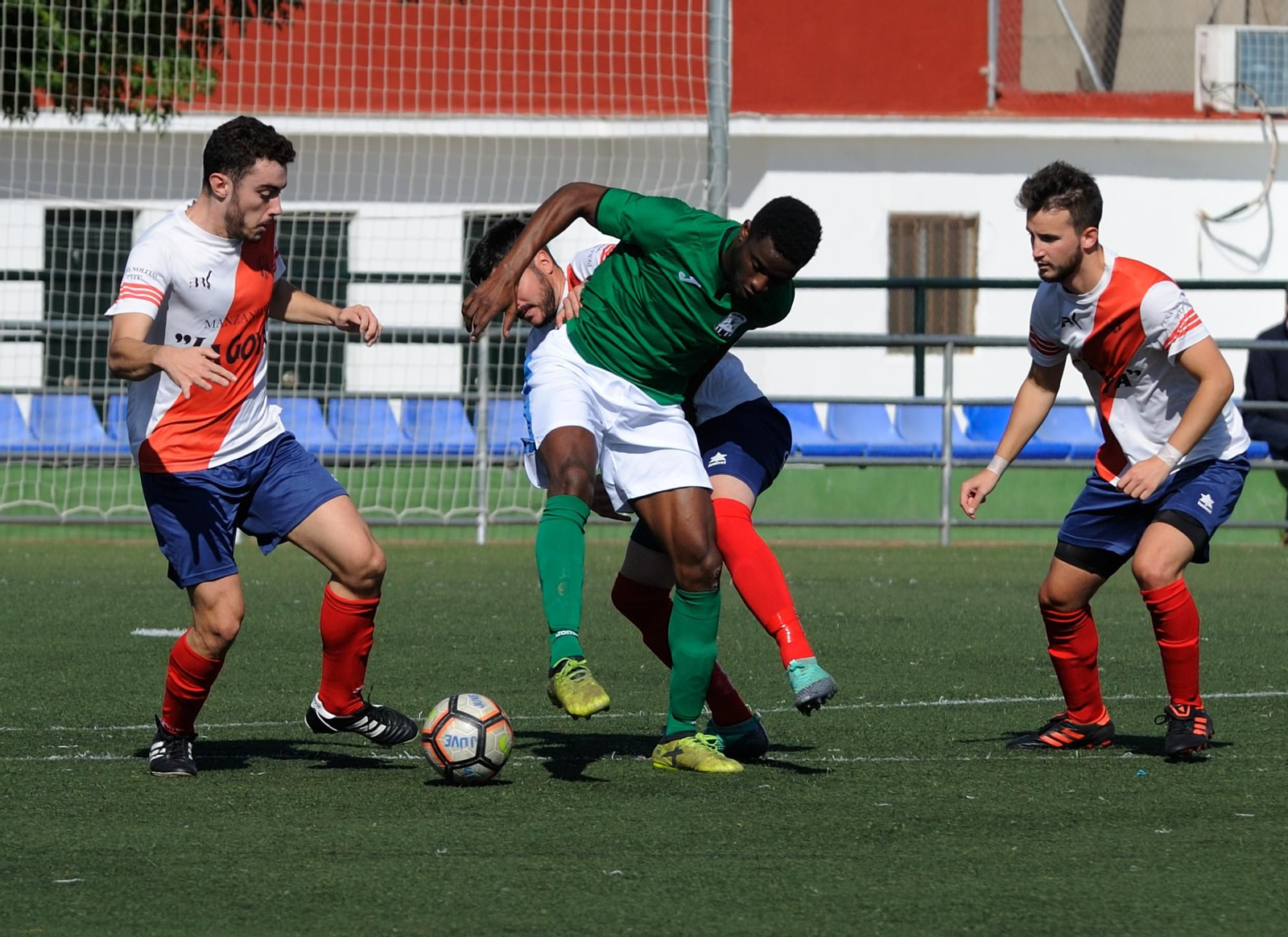 Pascu, rodeado por tres futbolistas de la Juventud Sanluqueña. Pascu, rodeado por tres futbolistas de la Juventud Sanluqueña.