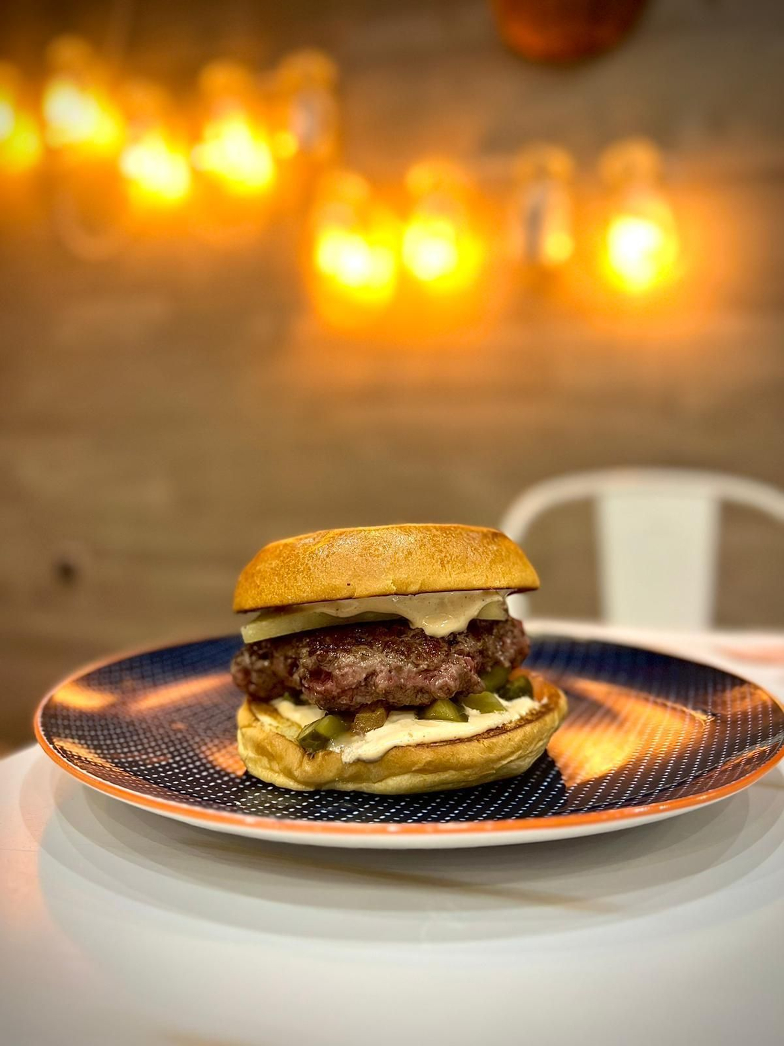 La Buey Linda lleva picadillo de tomate y pepinillo, un disco de 200grs. de buey madurado, queso curado con ceniza ahumado, abrazado por un pan brioche