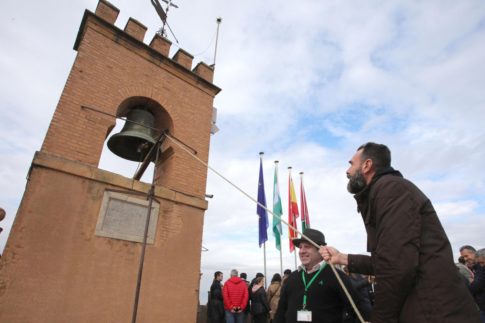 Un hombre hace tañer la campaña de la Torre de la Vela