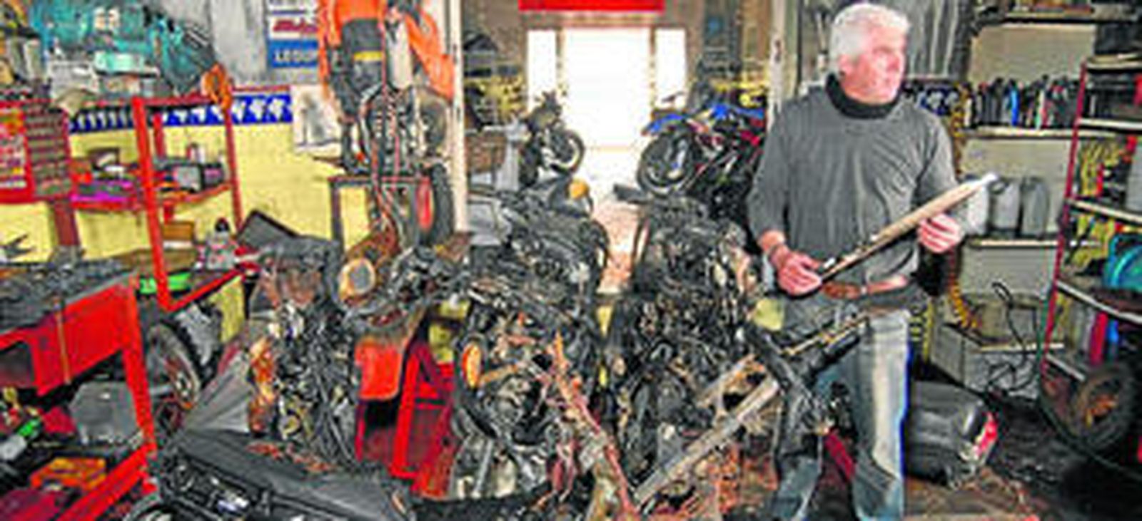 Un responsable del local, ayer junto a varias motos totalmente carbonizadas.