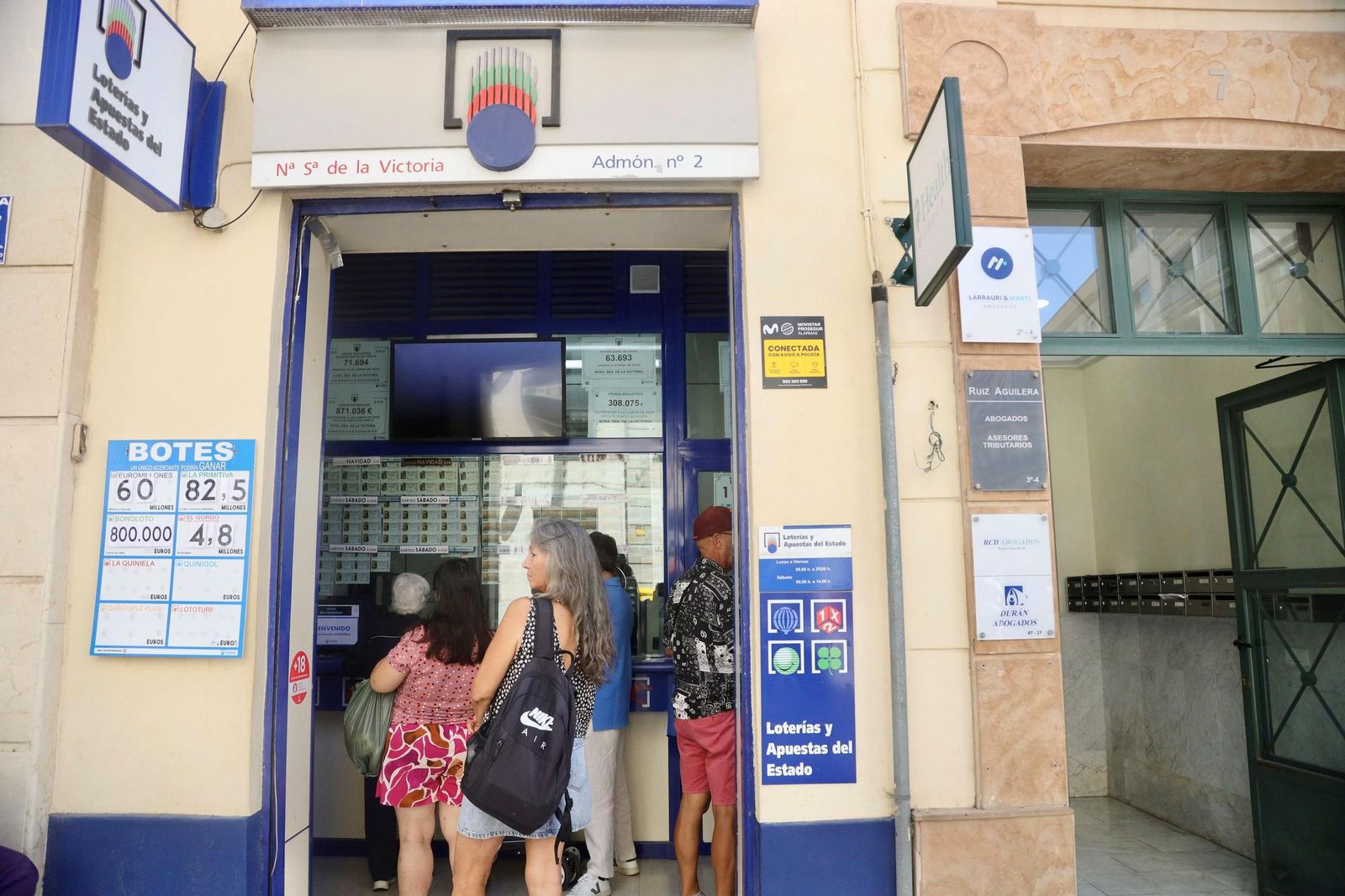 Varias personas en un establecimiento de venta de Loterías del centro de Málaga.