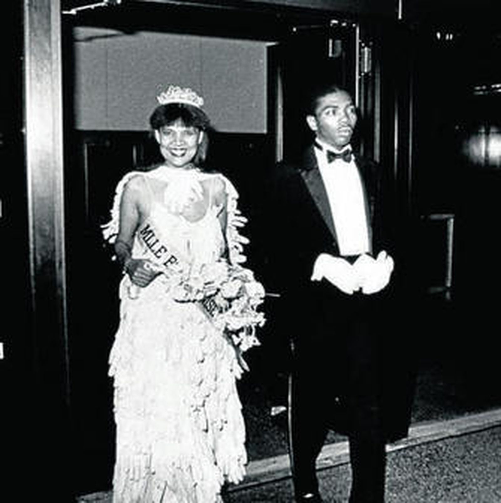 1. Lorraine O'Grady, ante varias obras de su serie 'Miscegenated Family Album', donde aparecen, emparentados con icónicas esculturas egipcias, los miembros de su familia y ella misma. 2. Una mujer pasa ante dos de los dípticos que conforman 'The First and the Last Modernists', serie dedicada a Baudelaire y Michael Jackson. 3. Vecinos de Harlem, Nueva York, ante la mirada divertida e intrigada de un policía durante una de sus 'performances' emblemáticas, 'Art is...'. 4. En su primera aparición pública en la escena artística neoyorquina,  una 'performance', no anunciada como tal, a la que llamó 'Mademoiselle Bourgeoise Noire'.