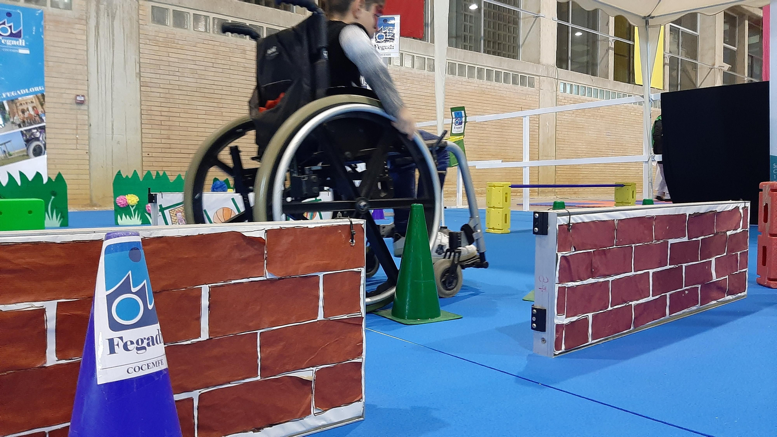 Un joven practica en silla de rueda en el stand de Fegadi Cocemfe en Juvelandia.