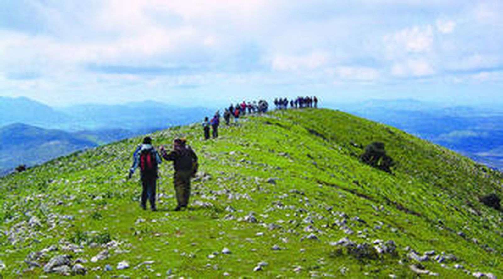 Unos viajeros hacen senderismo sobre el Peñón, en el municipio sevillano de Algámitas.