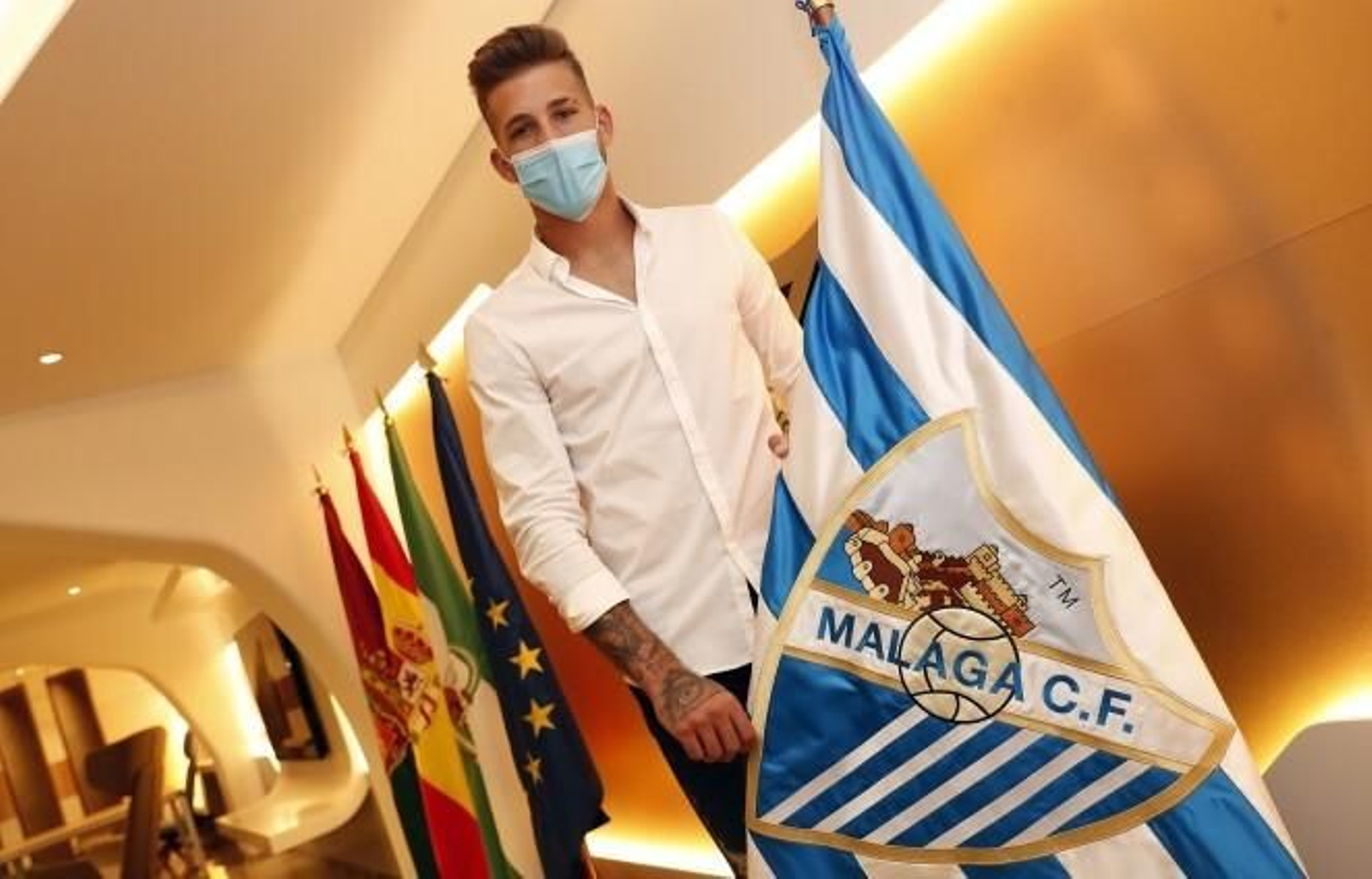 Kellyan posa con la bandera del Málaga tras su renovación.