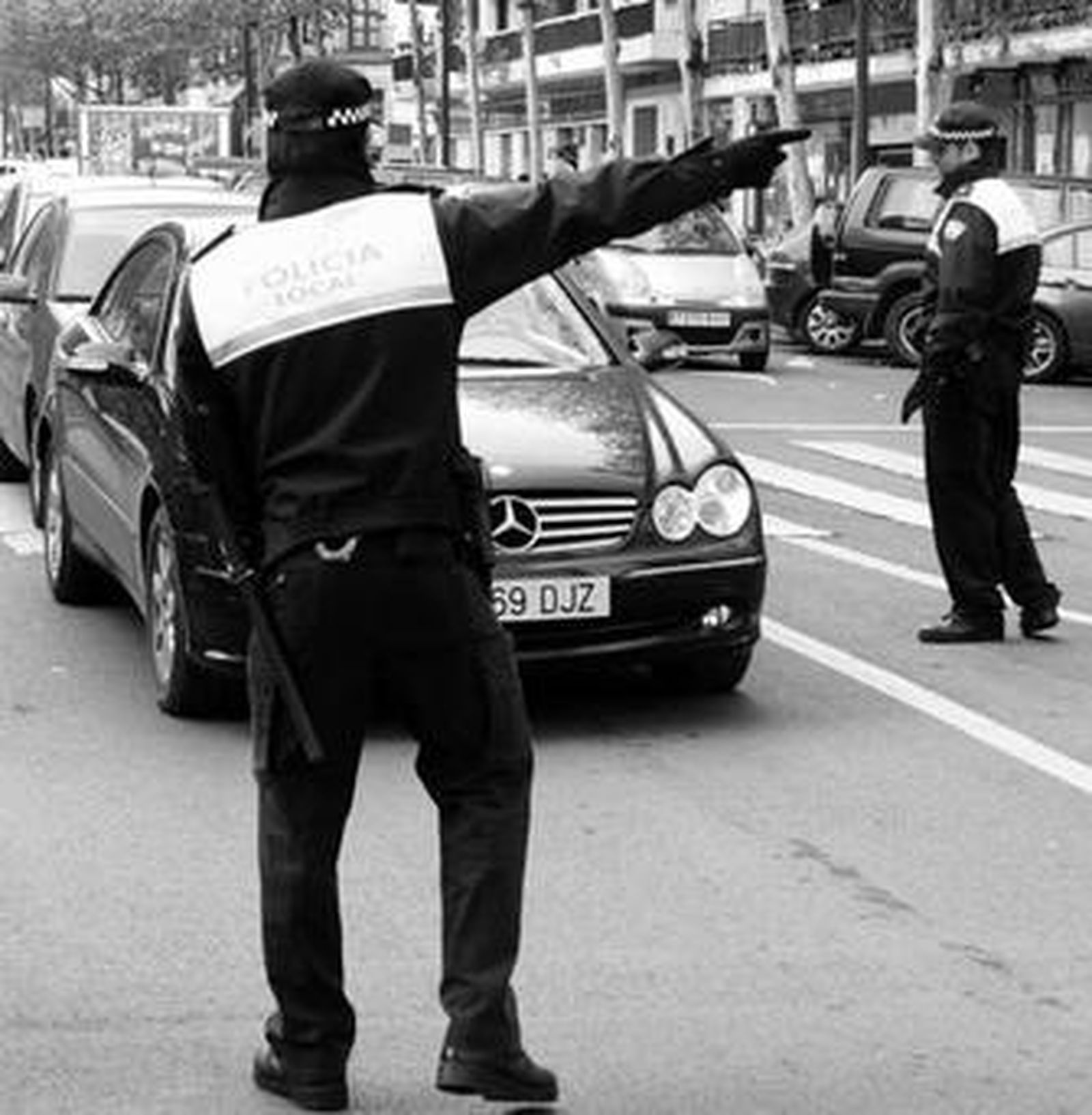 Dos agentes controlan el acceso de vehículos al centro en el control de Reyes Católicos.