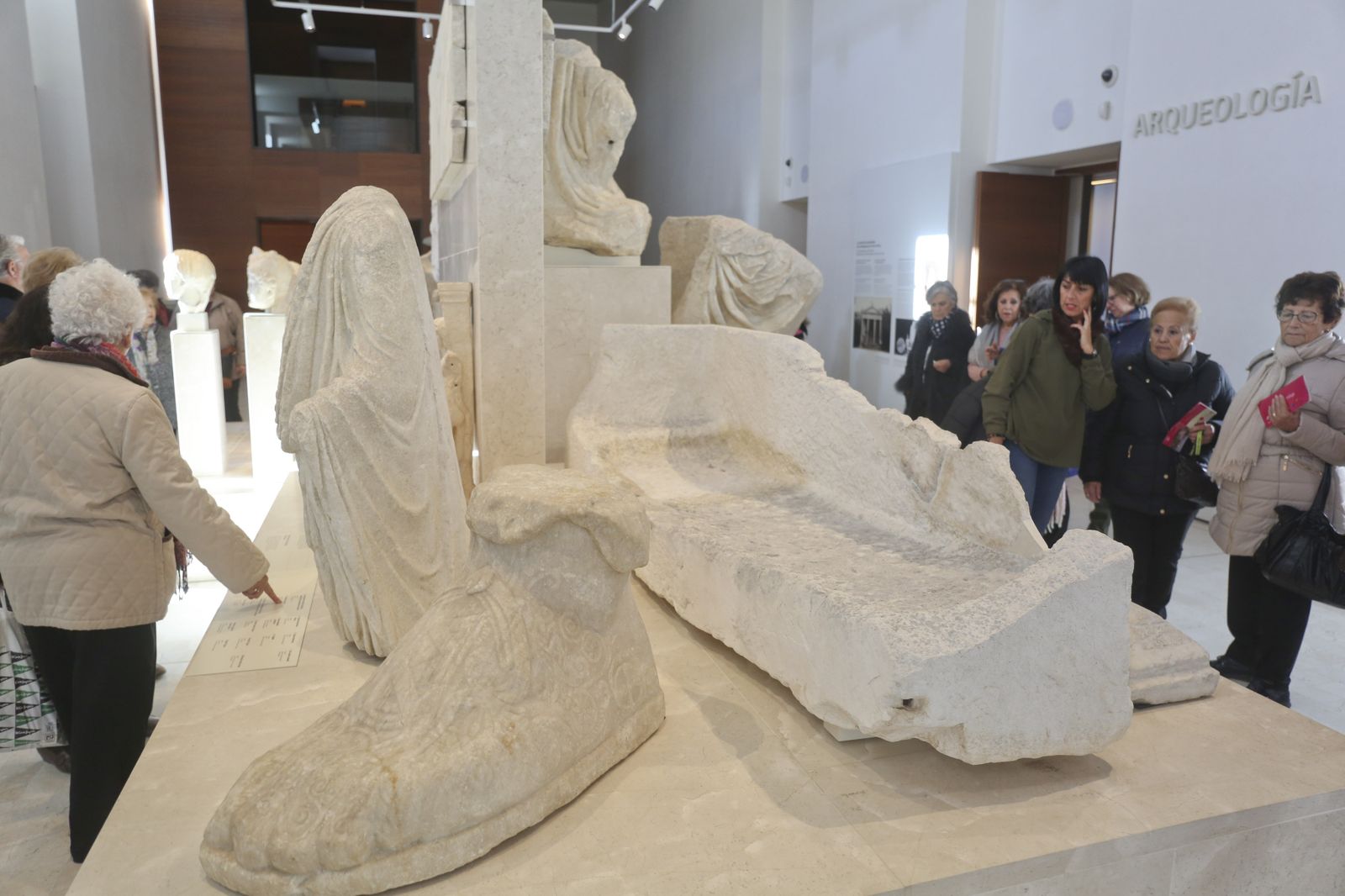 Varias personas observan piezas arqueológicas en el Museo de Málaga.