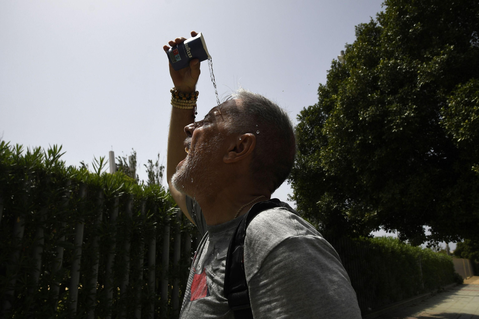 Una persona se moja la cabeza para combatir el calor sofocante de estos días en Almería