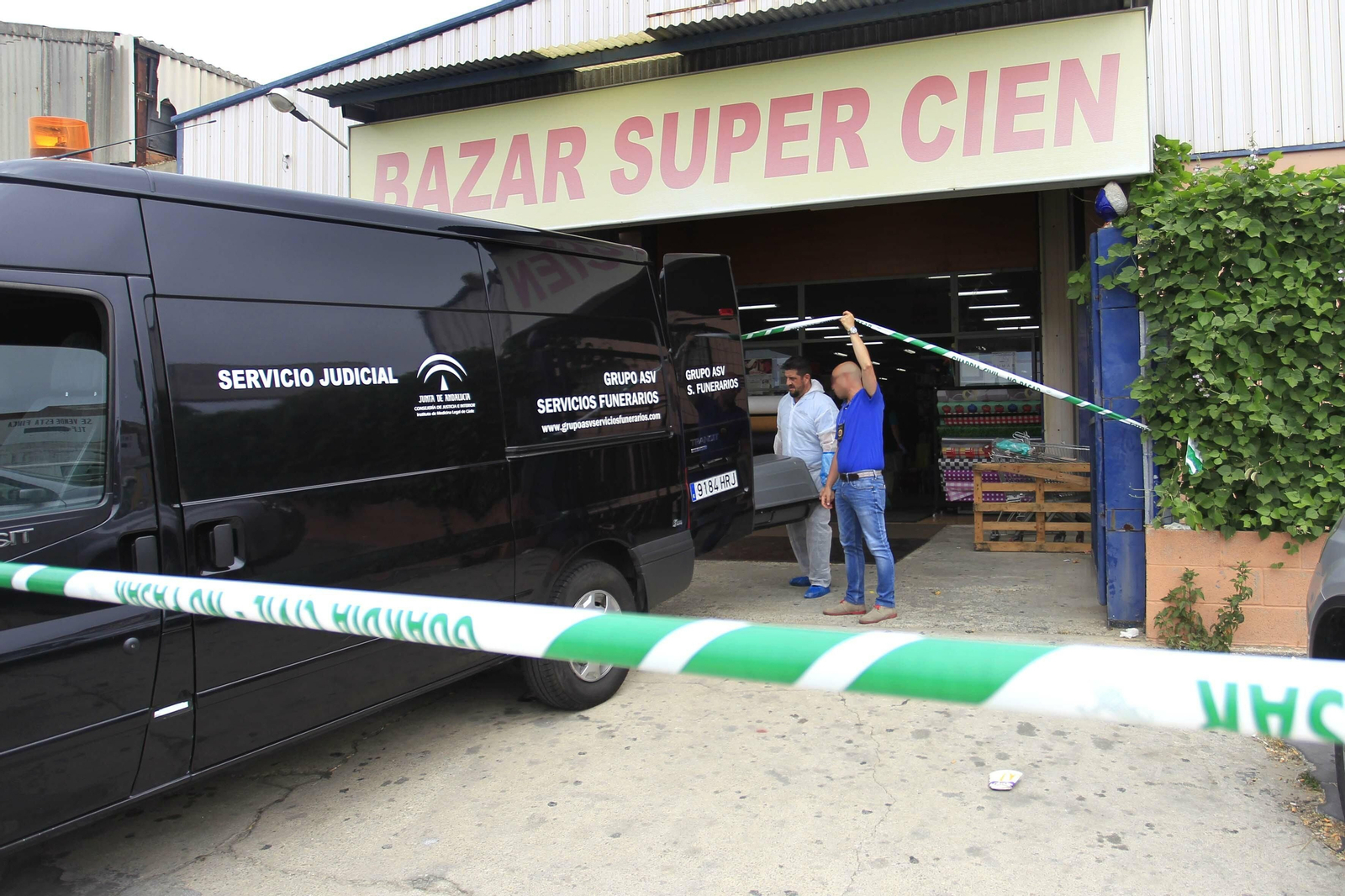 Los servicios funerarios retiran el cuerpo del fallecido el día del asesinato