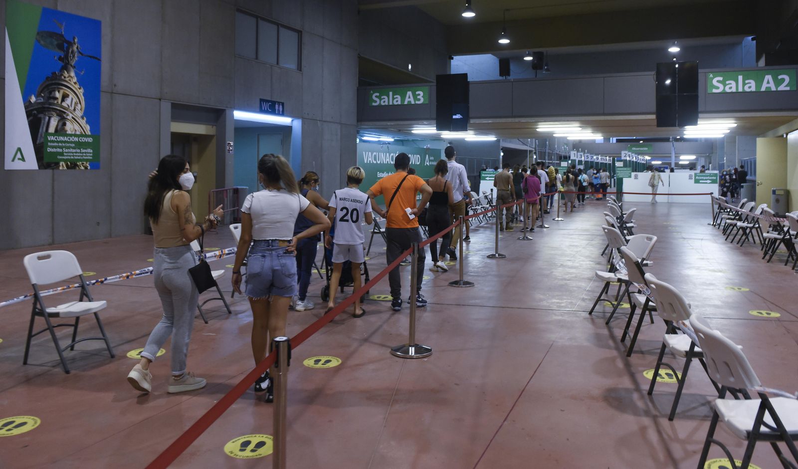 Adolescentes hacen cola en el Estadio de la Cartuja para recibir la vacuna contra el Covid.