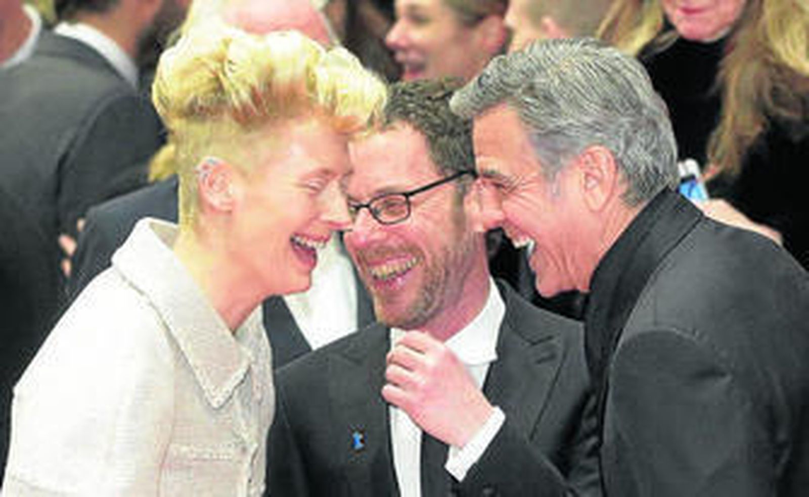 El director Ethan Coen, en el centro, bromea con Tilda Swinton y George Clooney en la Berlinale.