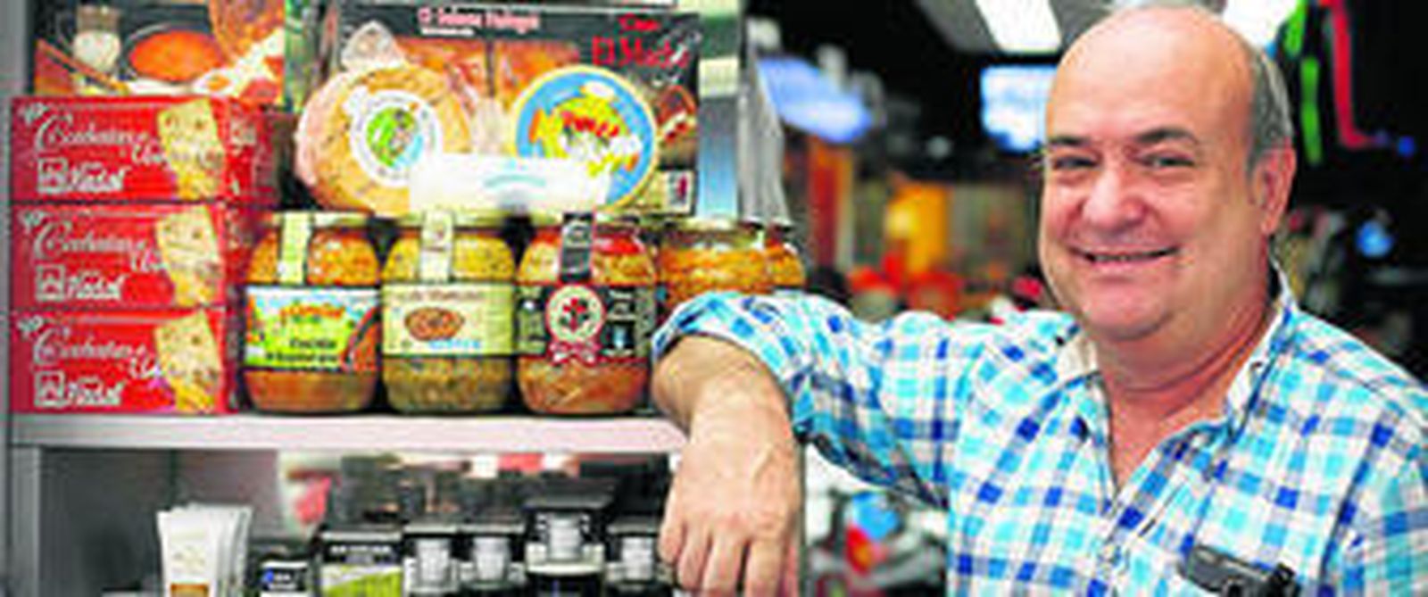 Miguel Pelayo García, propietario de la tienda, posa ante algunas de las delicatessen que vende al público.