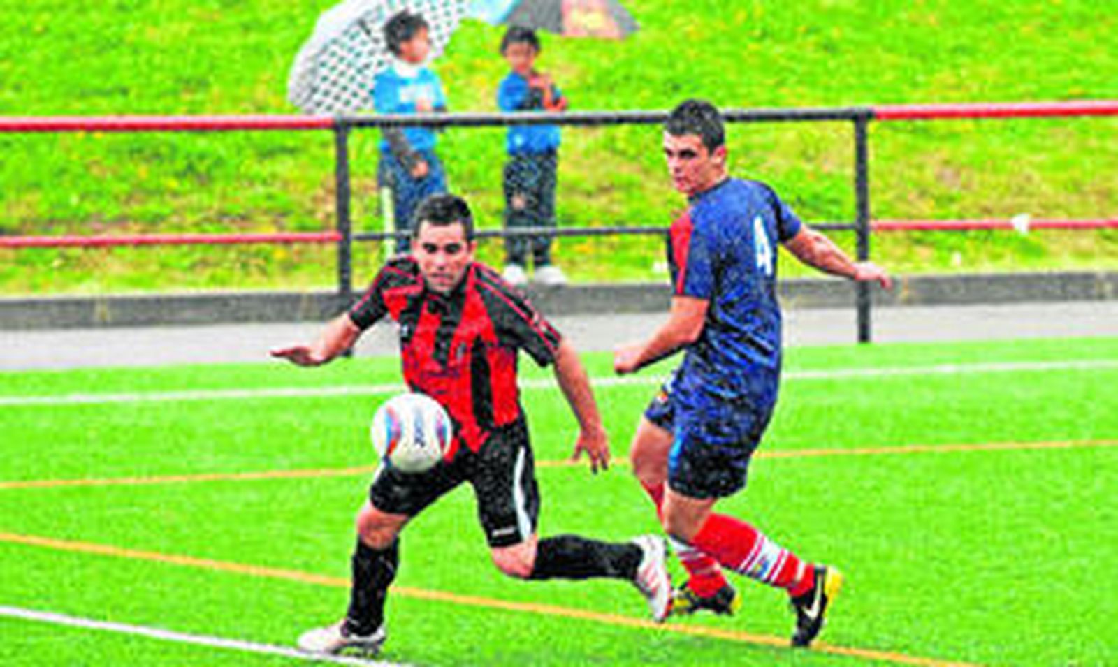 El tarifeño Cheito sigue a un rival, ayer en El Fontanal de Chiclana, bajo la lluvia.