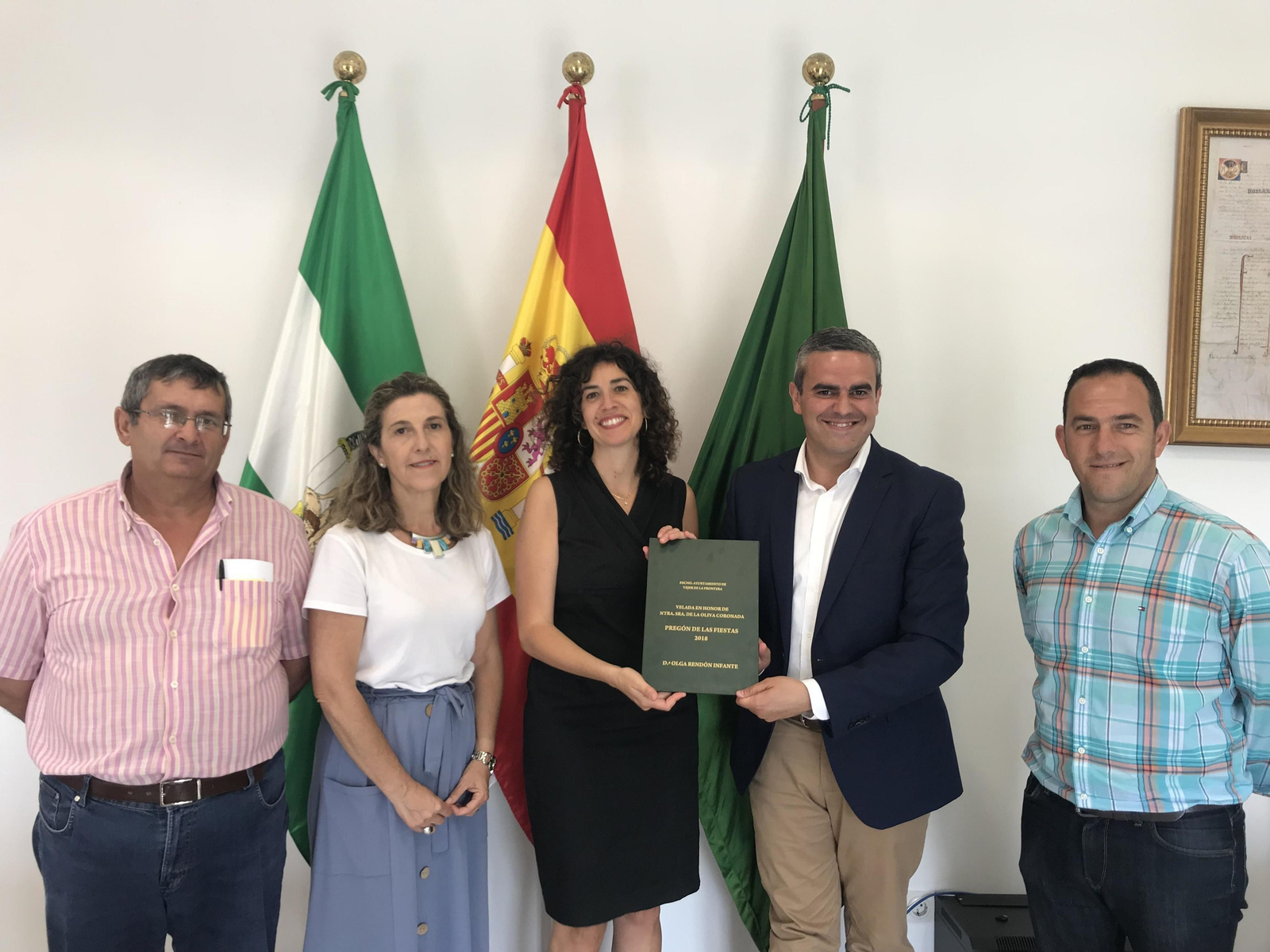 La pregonera, Olga Rendón, sostiene las tapas de su pregón junto al alcalde.