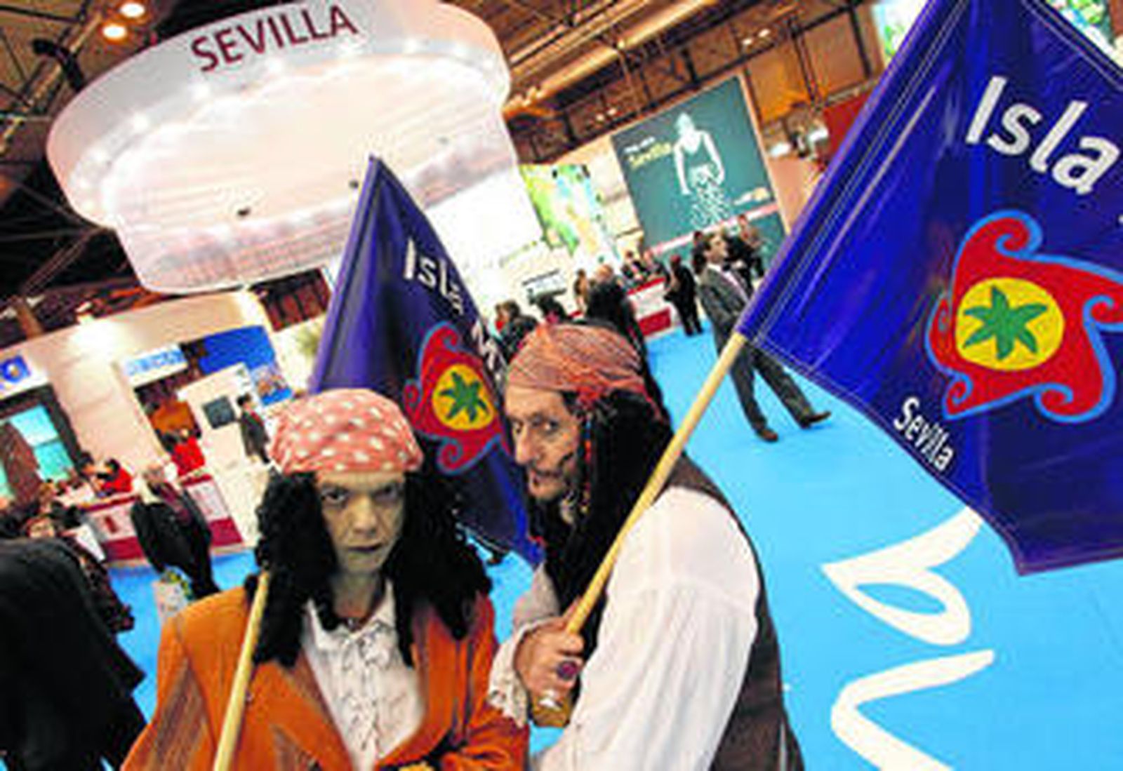 Dos personas disfrazadas de piratas promocionan Isla Mágica en el 'stand' de Sevilla, en Fitur.