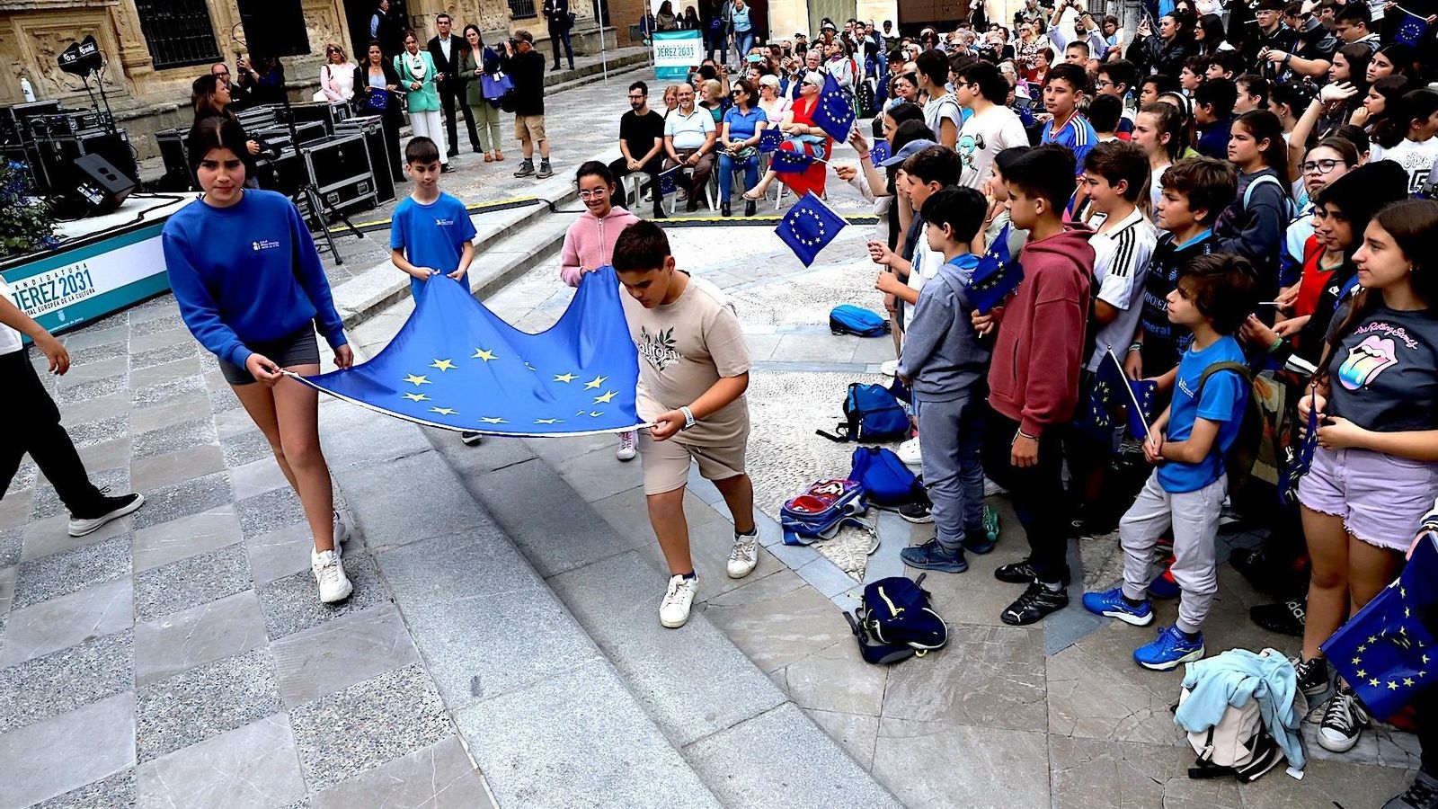 Escolares con la bandera europea para su izada.